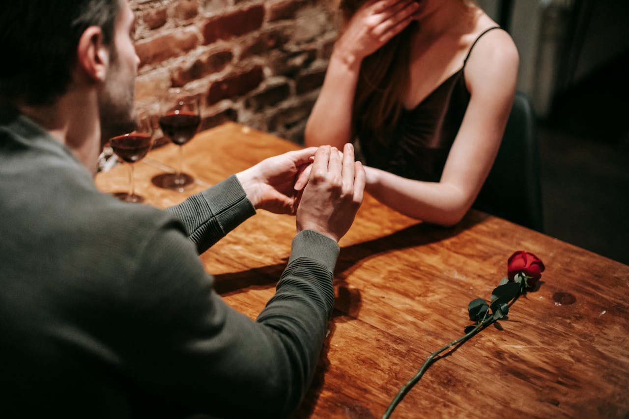 Ein Mann hält die Hand einer Frau während ihrer Verabredung zum Abendessen | Quelle: Pexels