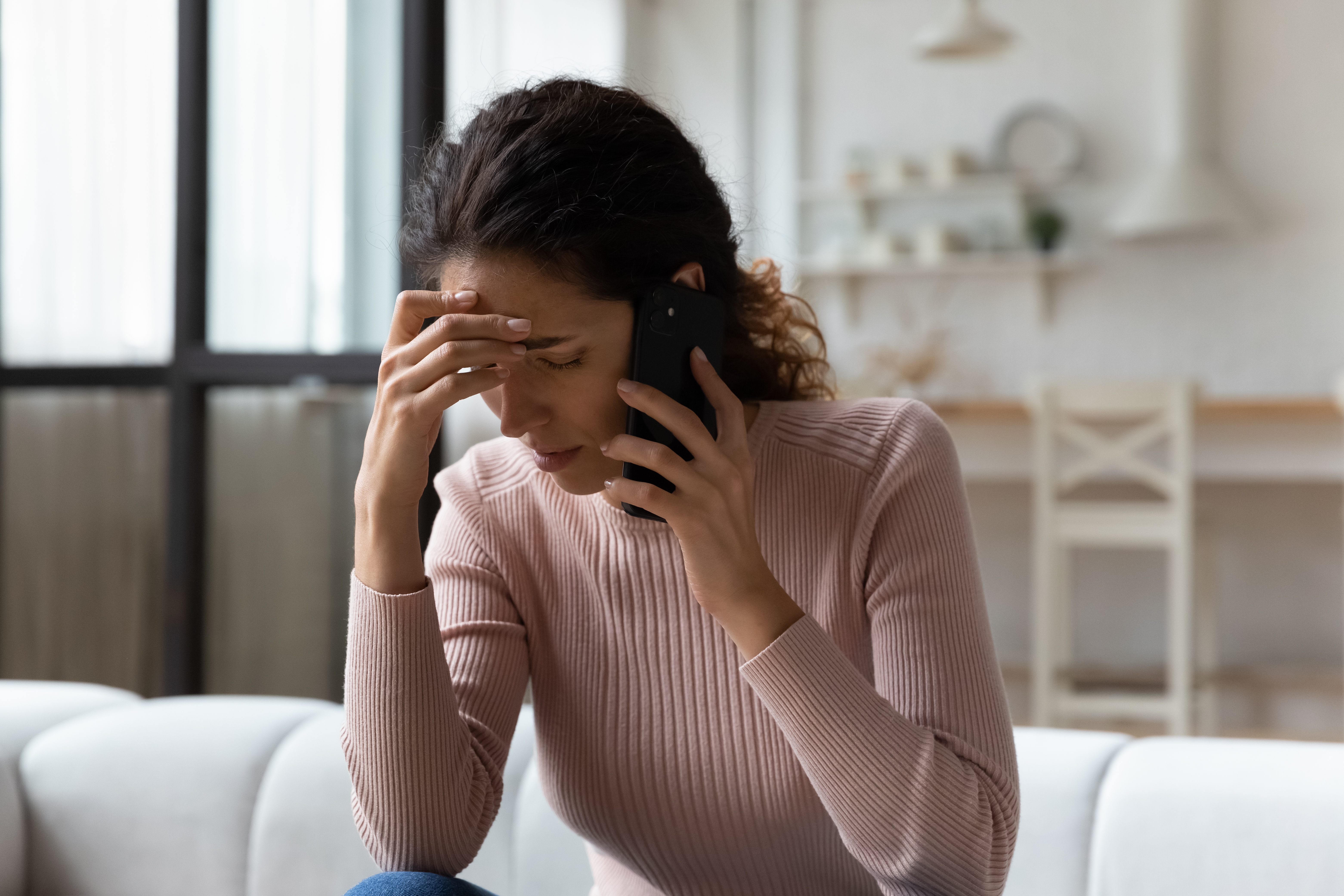 Besorgte Frau beim Telefonieren | Quelle: Shutterstock