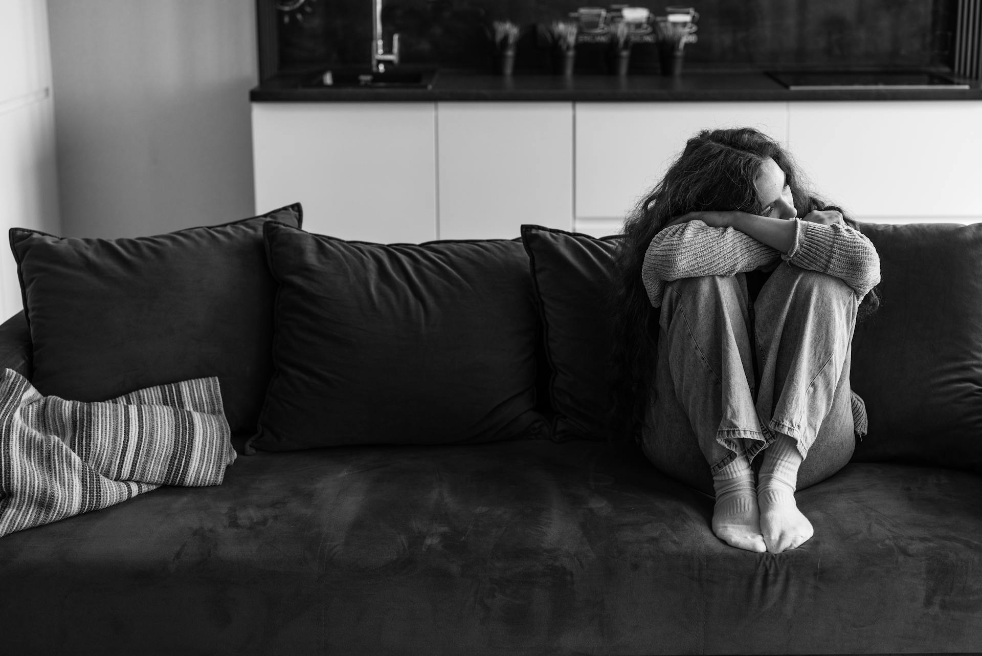 Smutna kobieta siedząca na kanapie | Źródło: Pexels