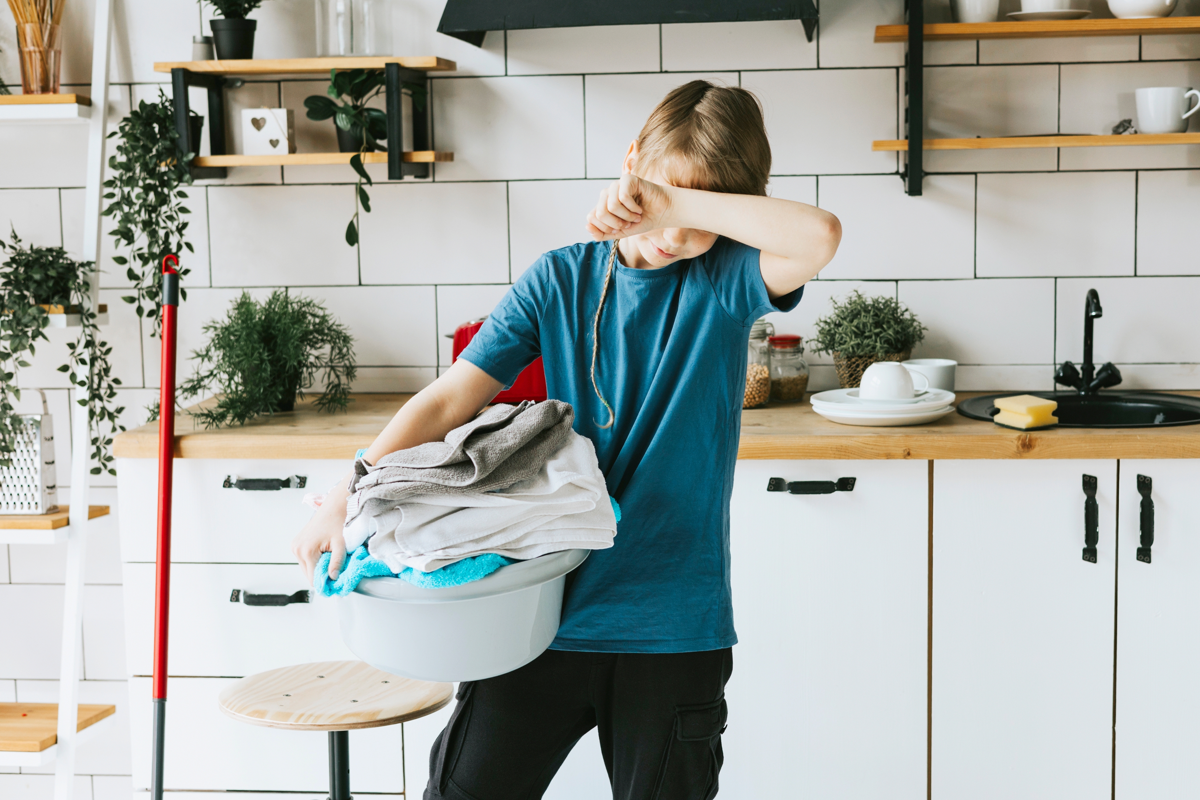 Junge trägt einen Wäschekorb | Quelle: Shutterstock
