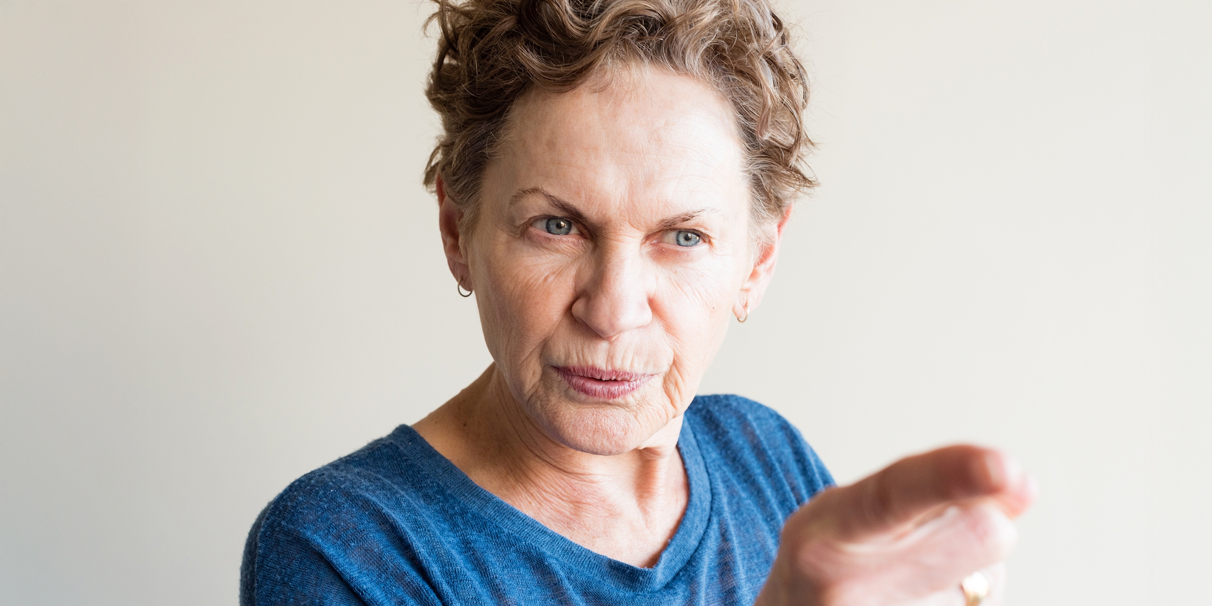 Eine alte Frau, die mit dem Finger zeigt | Quelle: Shutterstock
