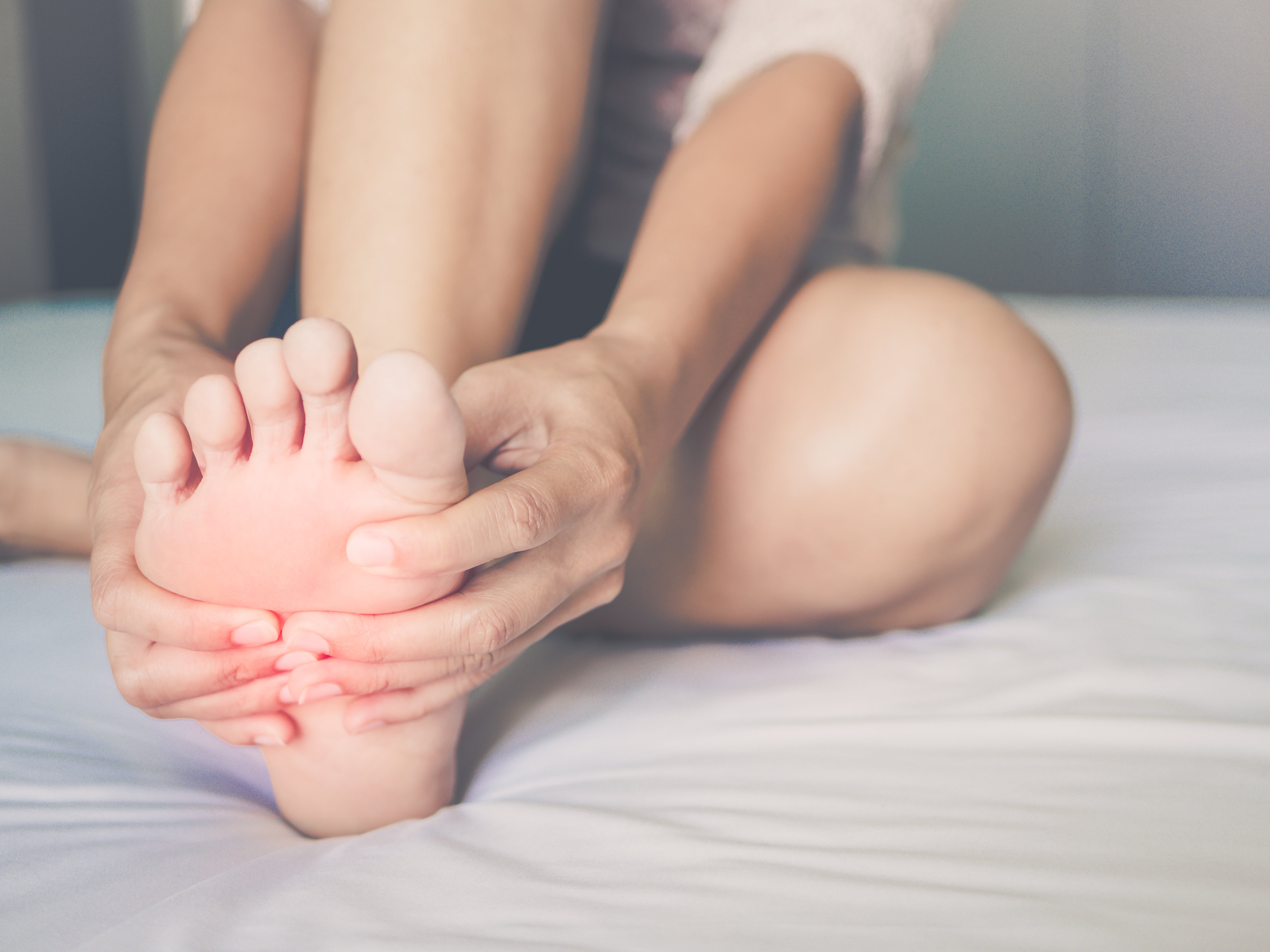 Frau reibt sich schmerzenden Fuß | Quelle: Shutterstock