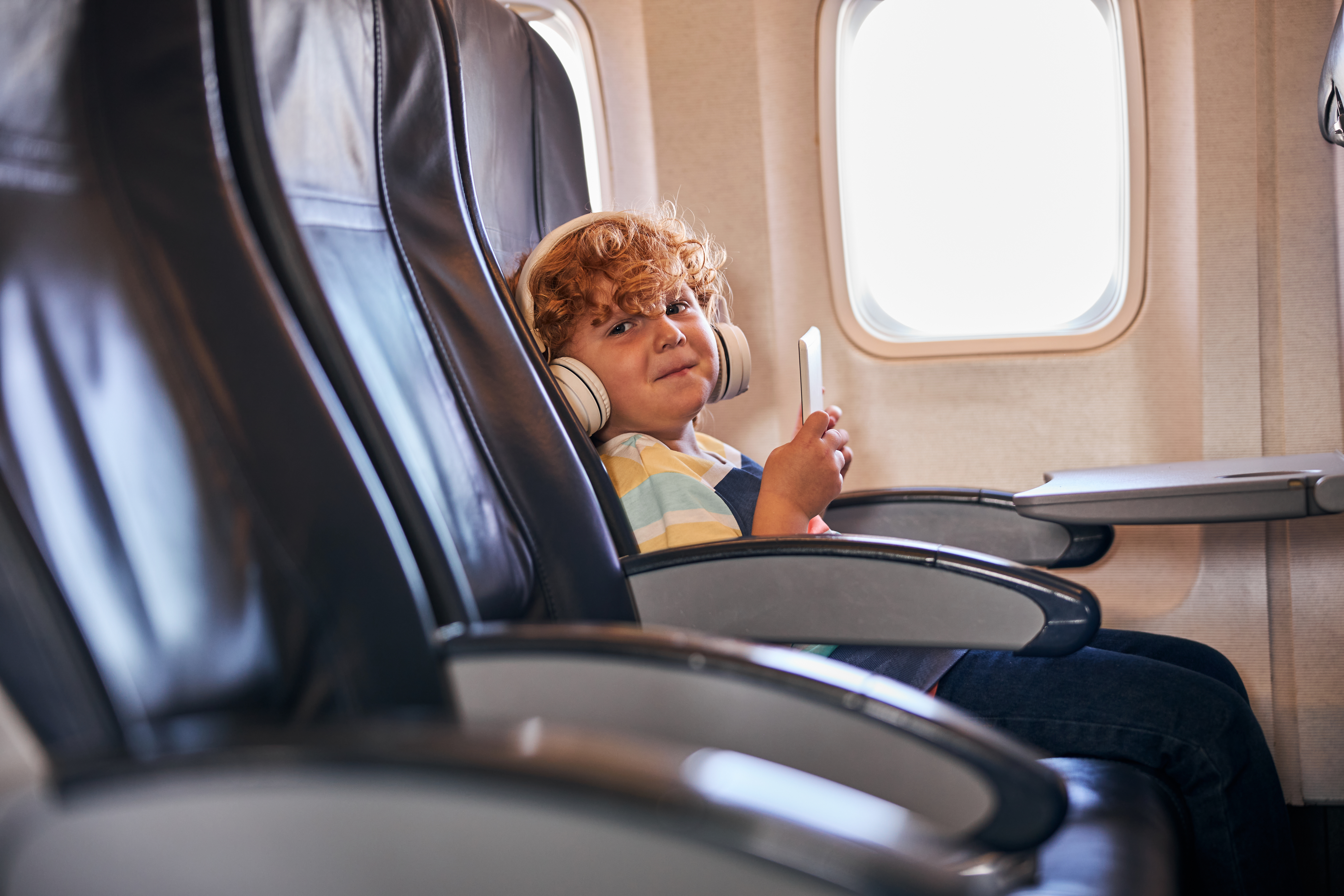 Ein schelmisches Kind in einem Flugzeug | Quelle: Shutterstock
