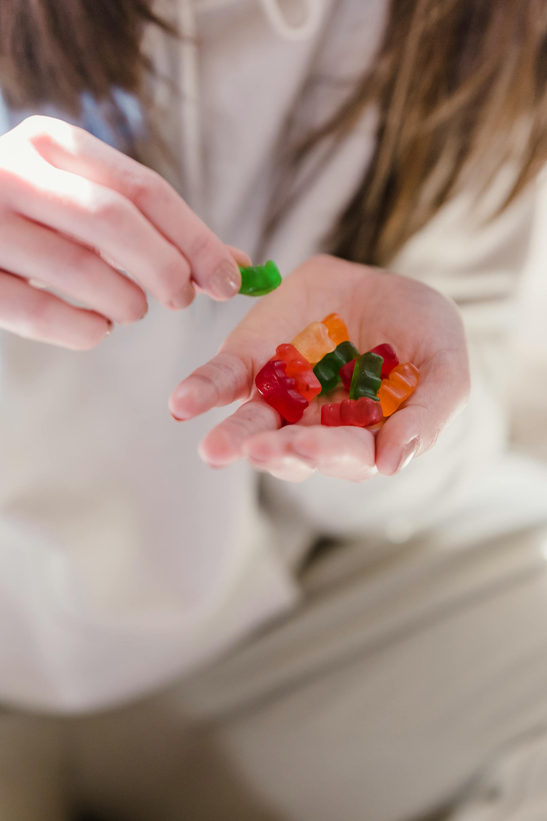 Eine Frau wählt ein einzelnes Gummibärchen aus | Quelle: Pexels