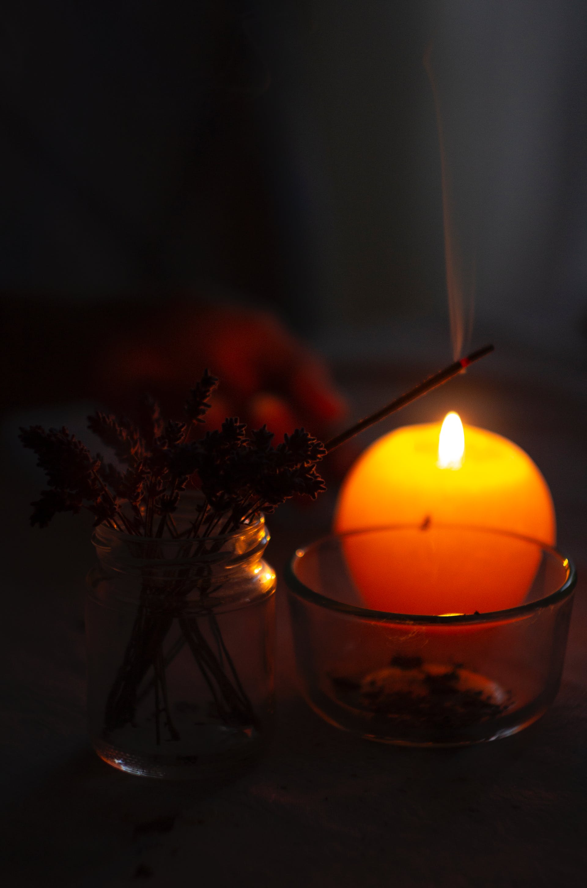 Etwas angezündeter Weihrauch und eine brennende Kerze | Quelle: Pexels