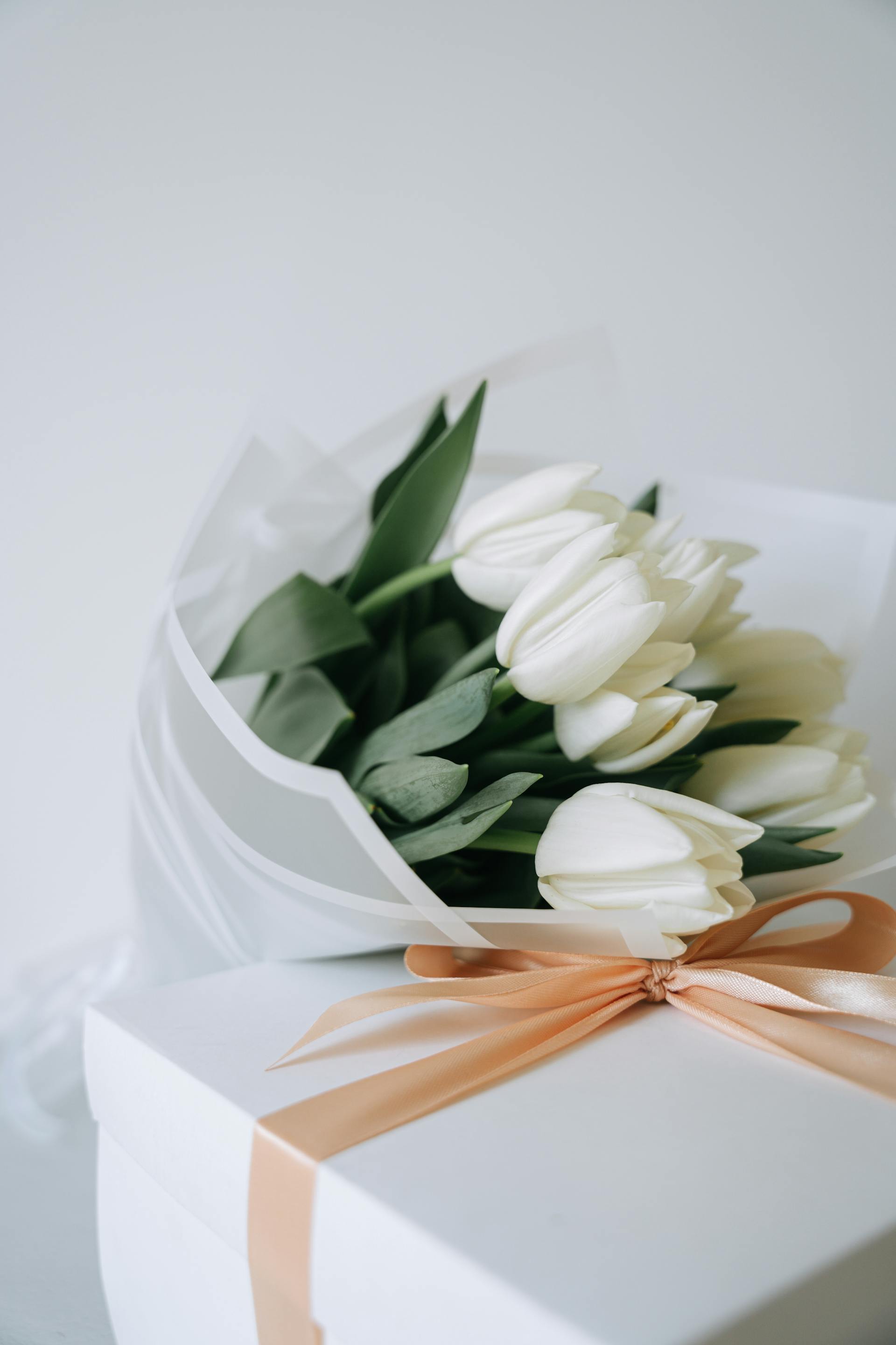 Ein Strauß weißer Tulpen und eine Geschenkbox | Quelle: Pexels
