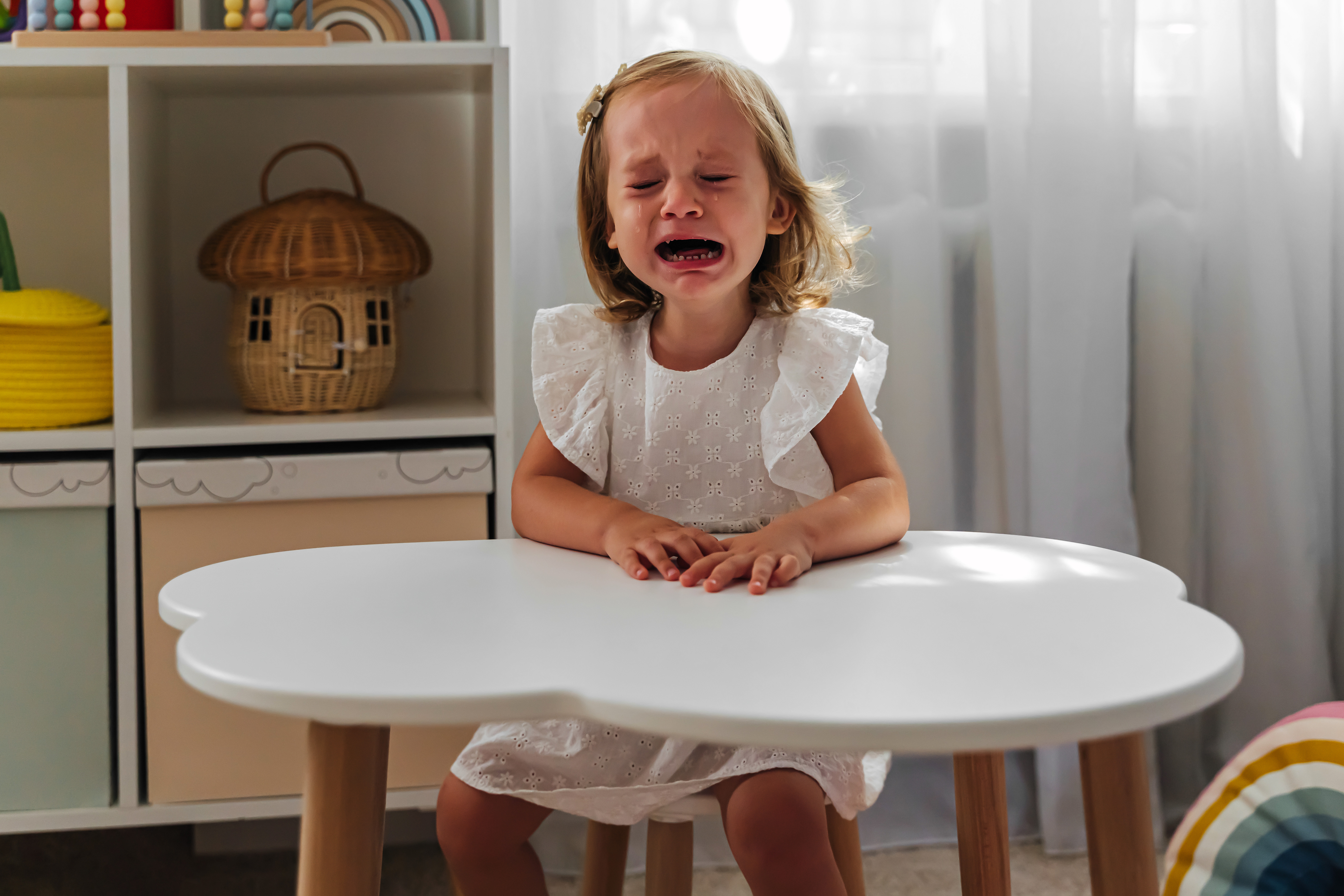 Ein kleines Mädchen weint, während es in seiner Klasse am Tisch sitzt | Quelle: Getty Images