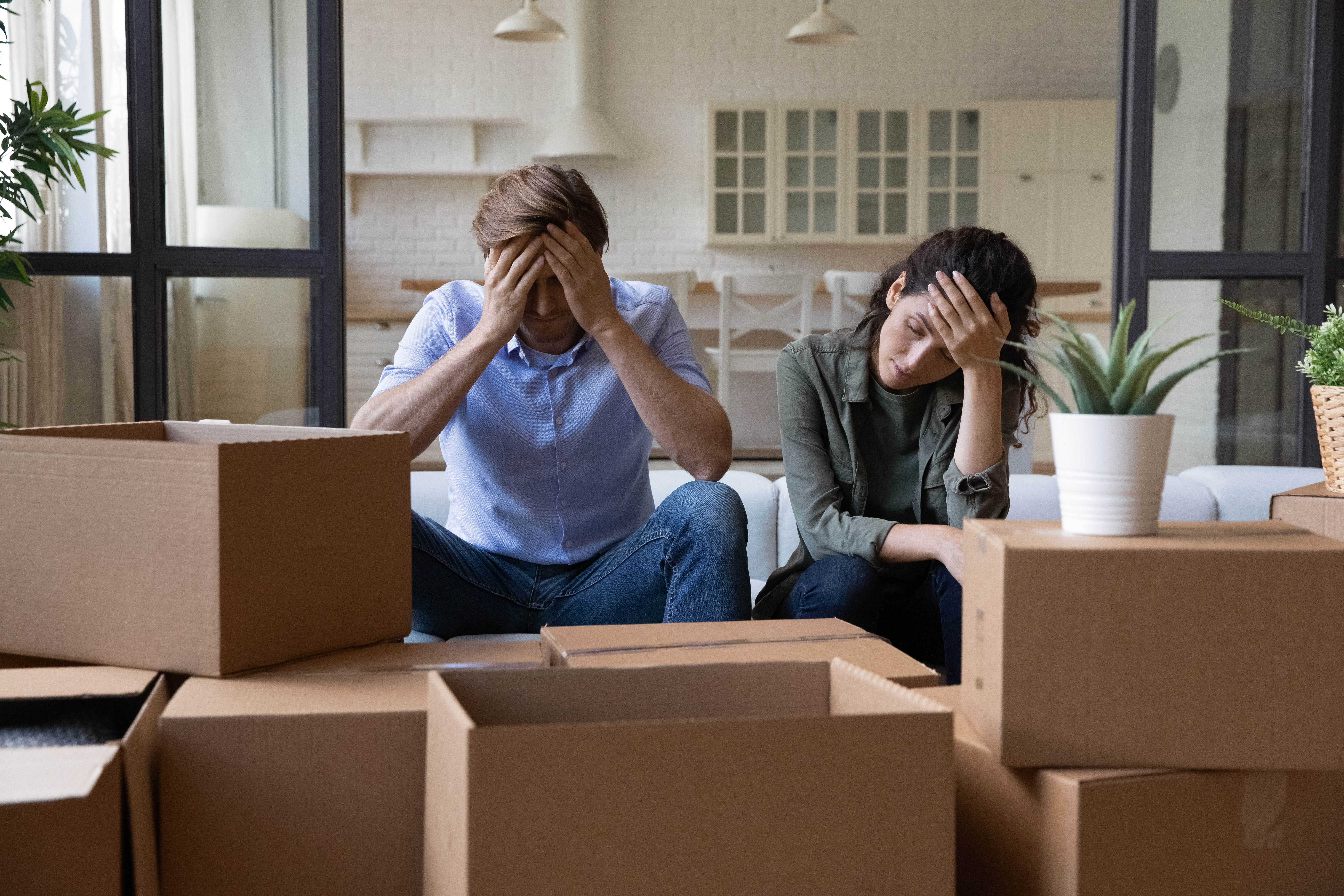 Ein gestresstes Paar, umgeben von Kisten | Quelle: Shutterstock