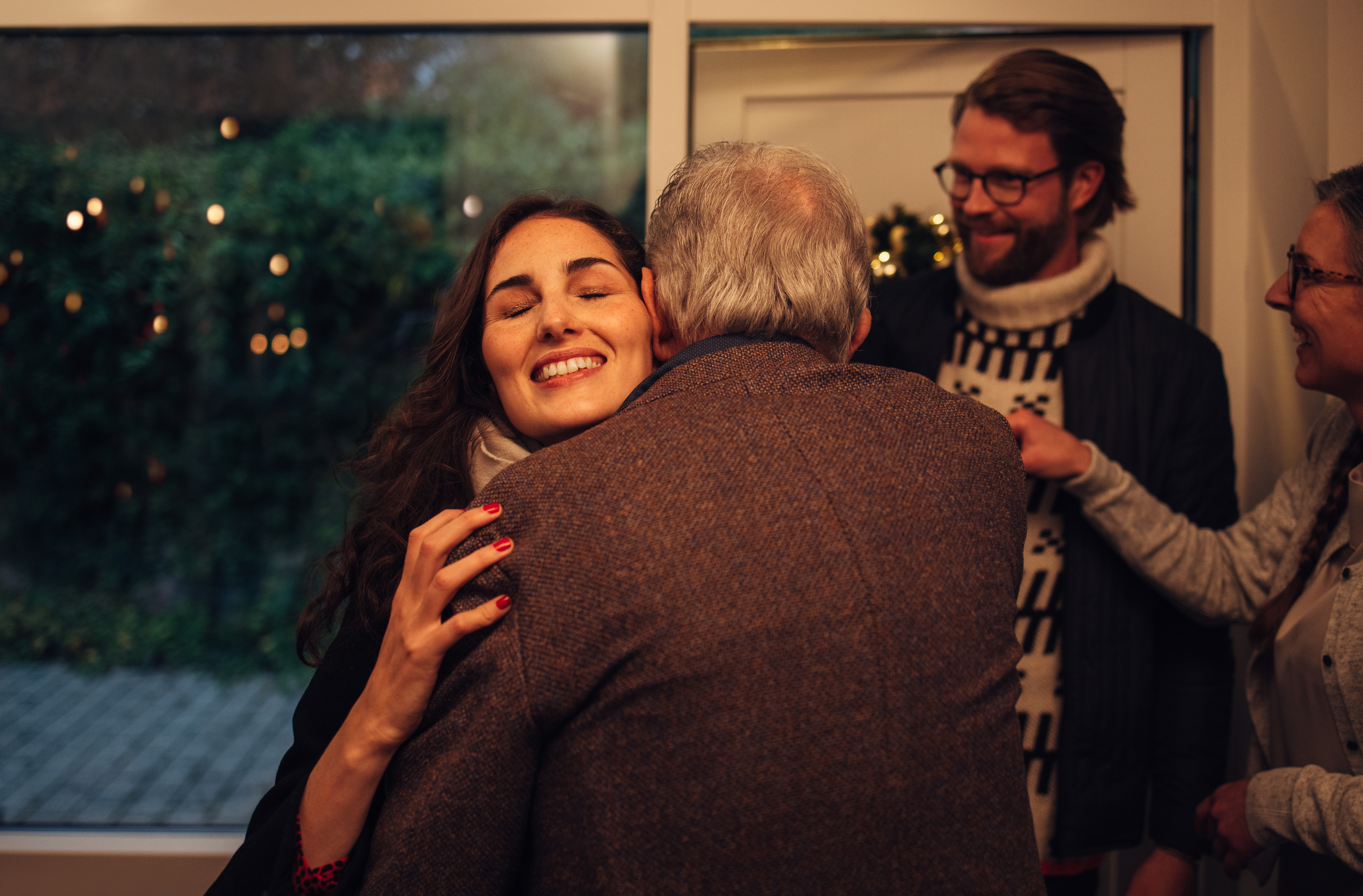Frau, die ihre Eltern umarmt | Shutterstock