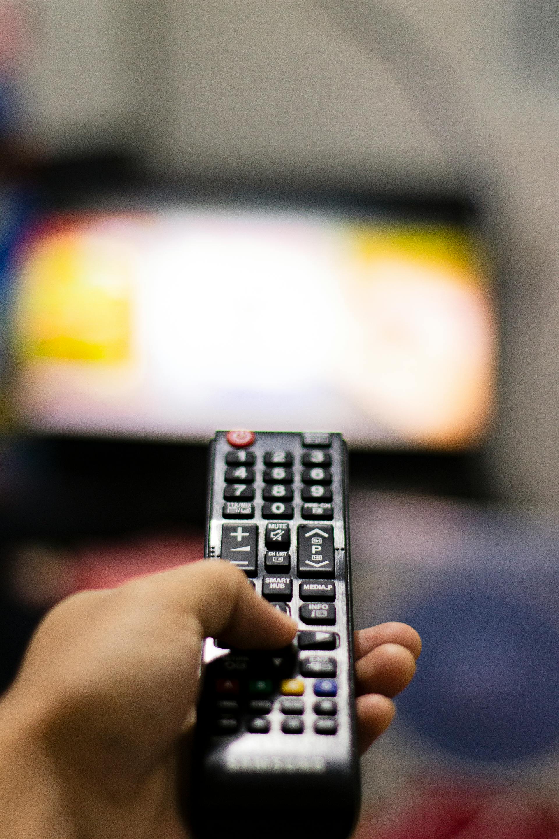 Eine Person hält eine TV-Fernbedienung | Quelle: Pexels