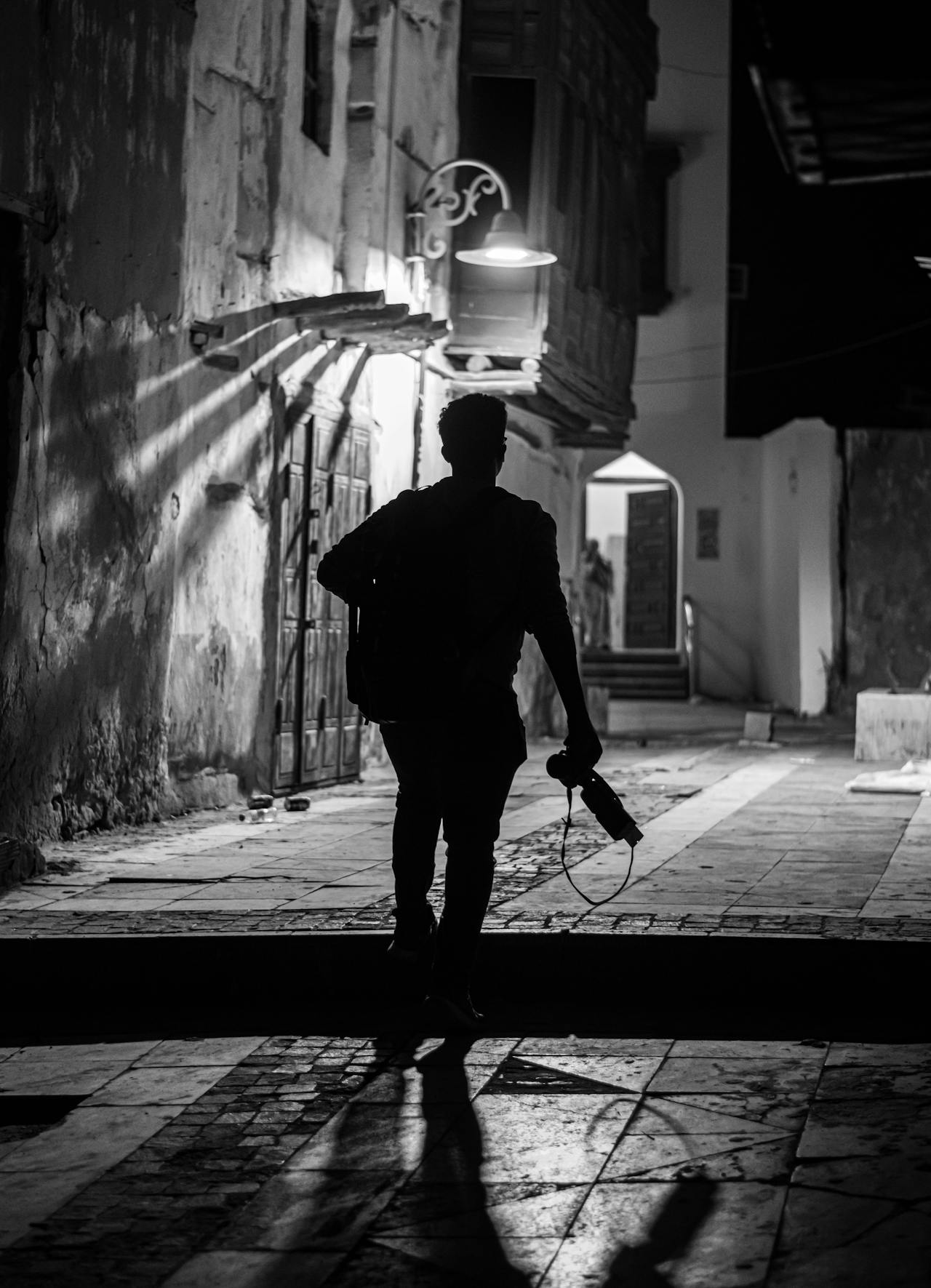 Ein junger Mann läuft nachts durch eine Gasse | Quelle: Pexels