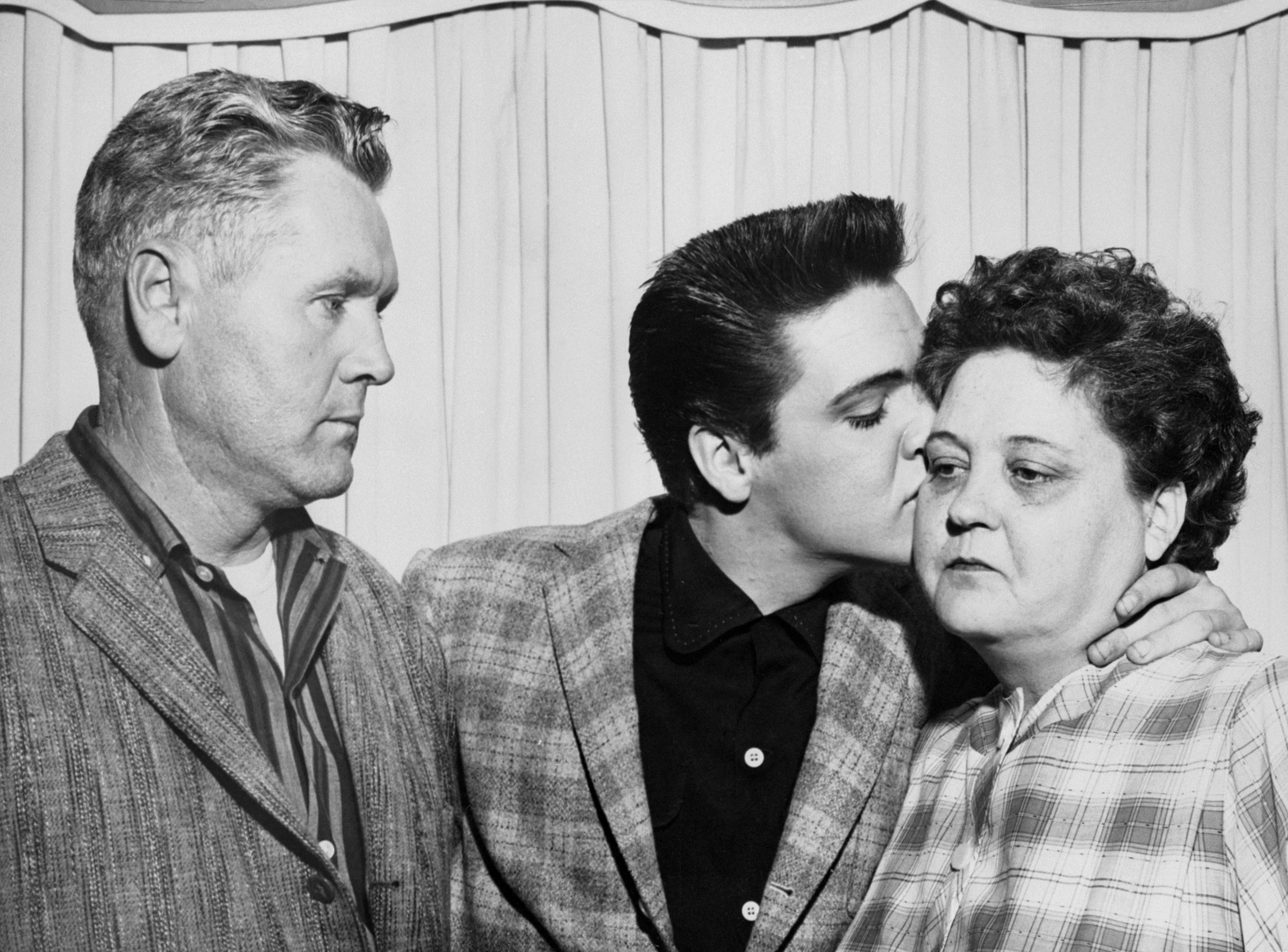 Sänger Elvis Presley küsst seine Mutter Gladys am Vorabend seiner Einberufung in die Armee und links ist sein Vater Vernon.  |  Quelle: Getty Images