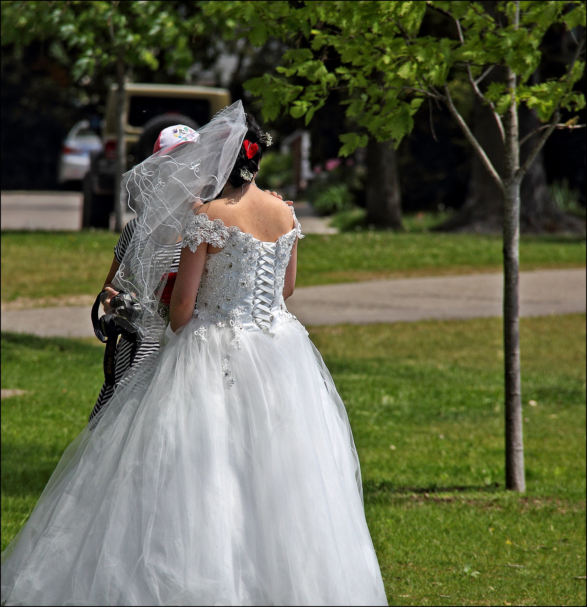 Die Rückenansicht einer im Freien stehenden Braut | Quelle: Flickr
