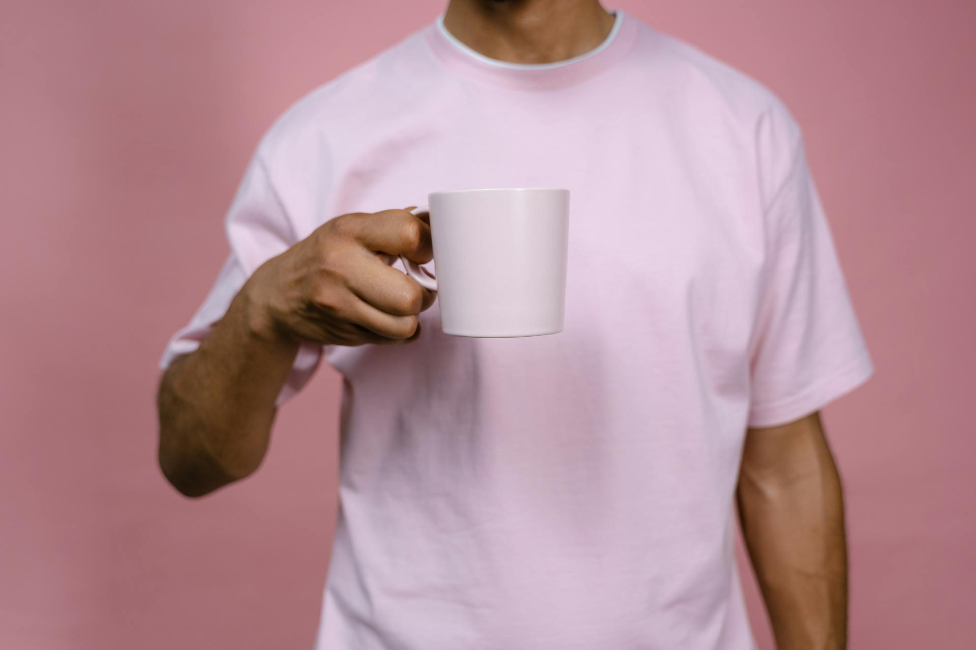 Ein Mann hält einen weißen Keramikbecher | Quelle: Pexels