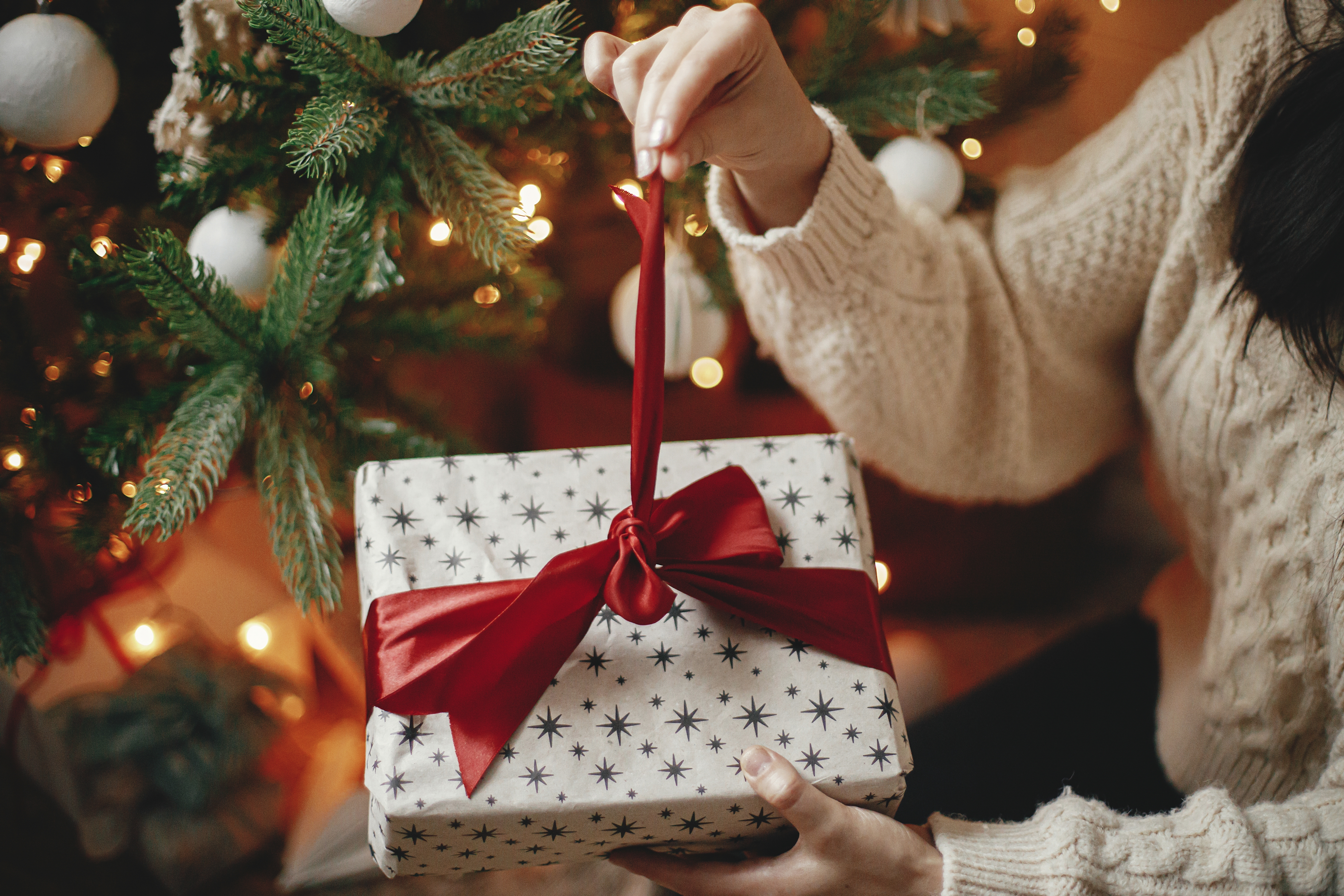 Eine Frau öffnet ein Weihnachtsgeschenk | Quelle: Shutterstock