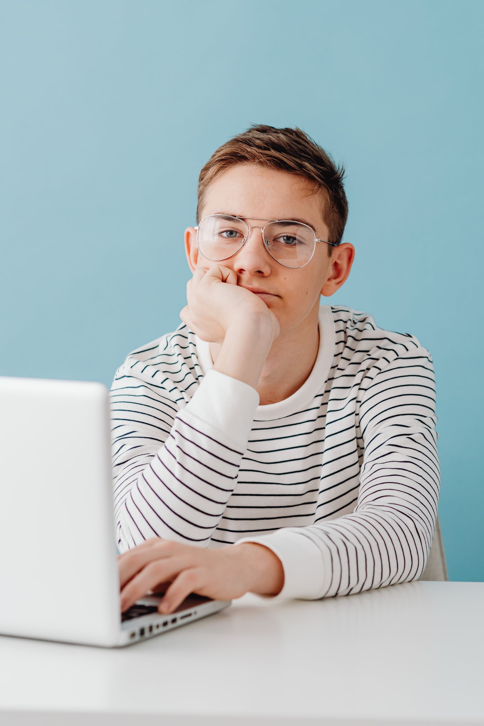 Jugendlicher Junge mit Laptop sitzend | Quelle: Pexels
