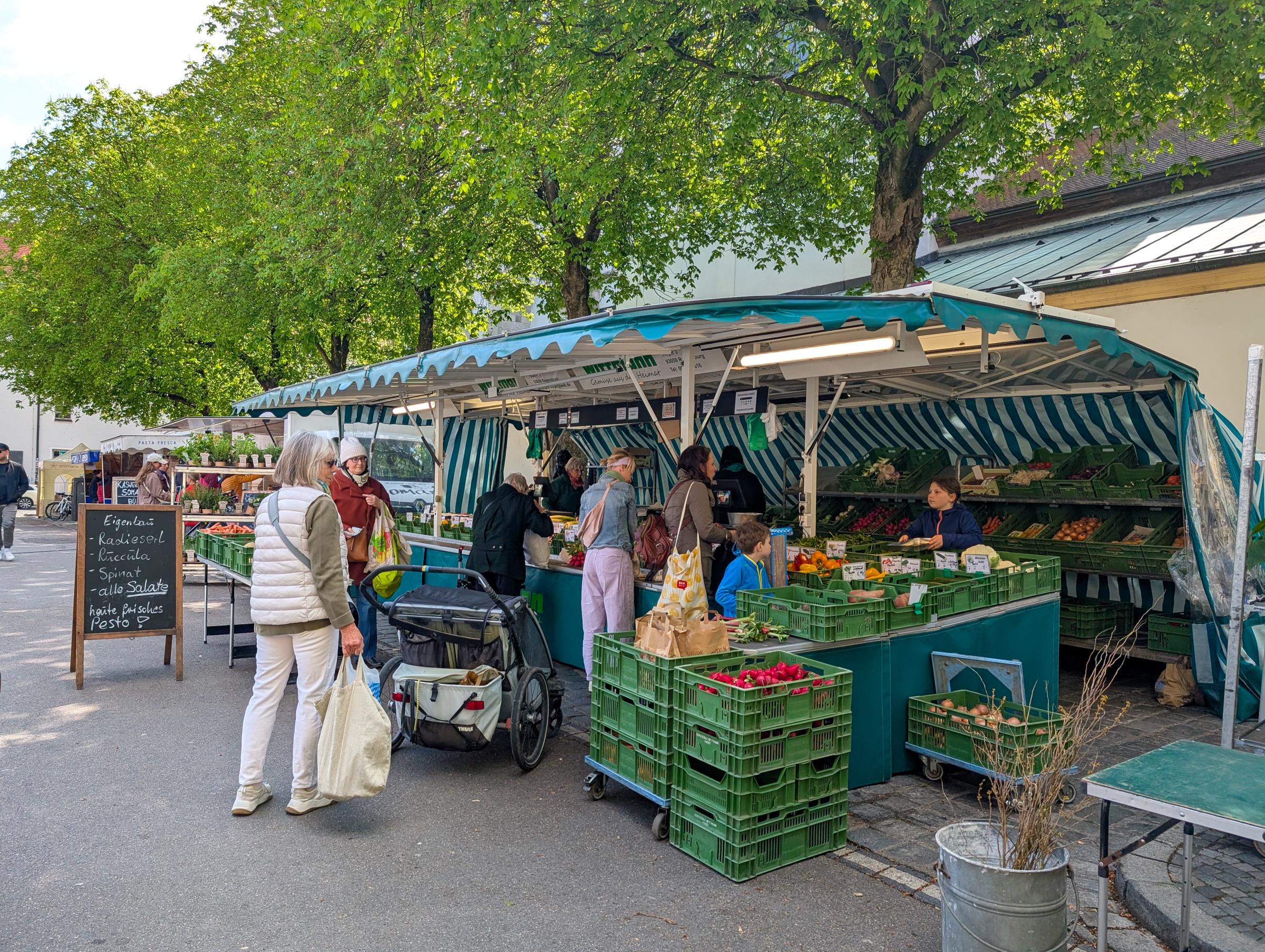 Kunden kaufen frisches Gemüse, Obst und Kräuter auf einem Obst- und Gemüsemarkt im Freien | Quelle: Getty Images