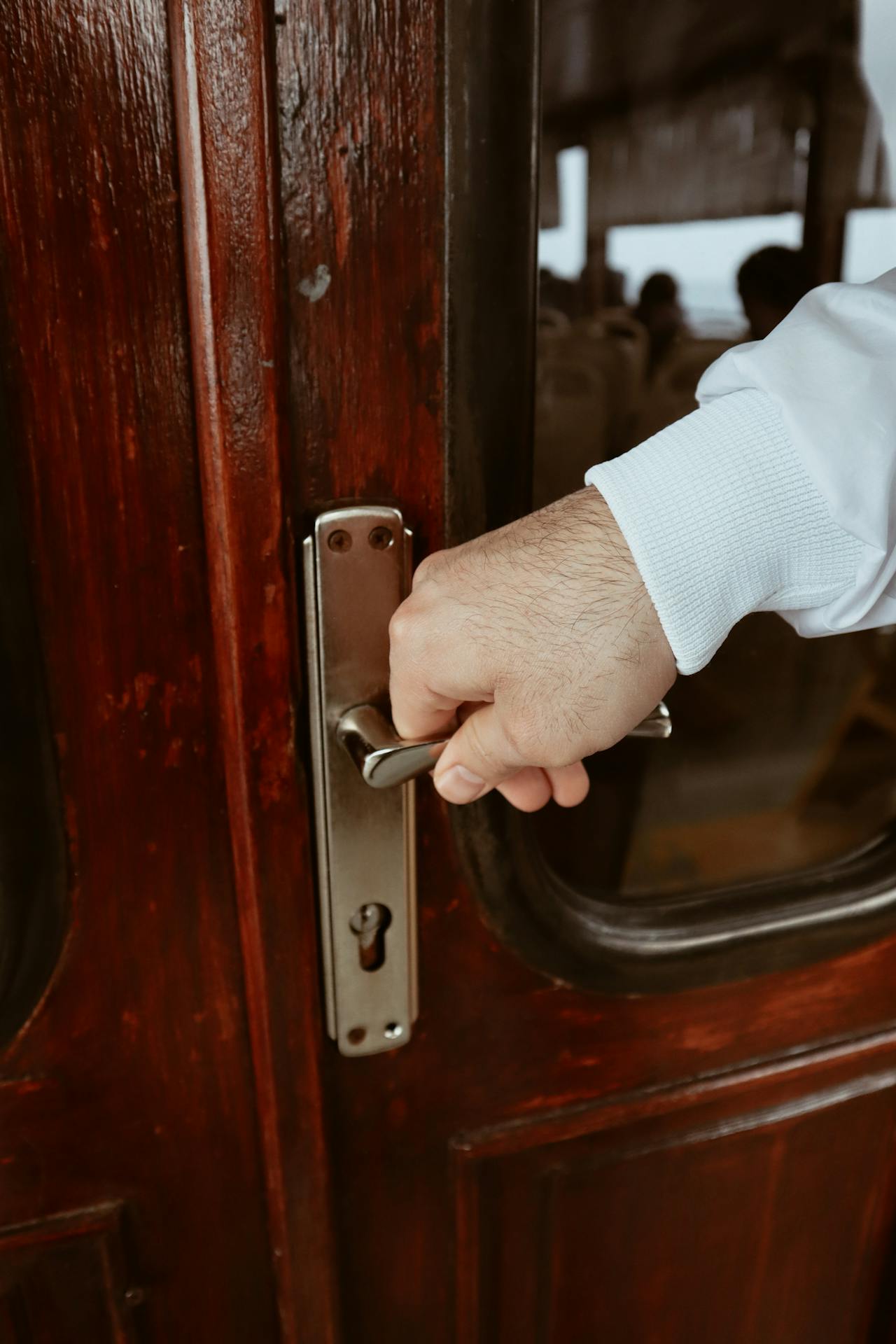 Clsoe-up-Aufnahme eines Mannes, der eine Türklinke hält | Quelle: Pexels