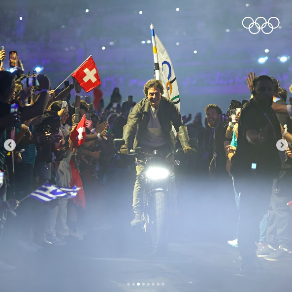 Tom Cruise fährt mit der olympischen Flagge davon, gepostet am 11. August 2024 | Quelle: Instagram/olympics