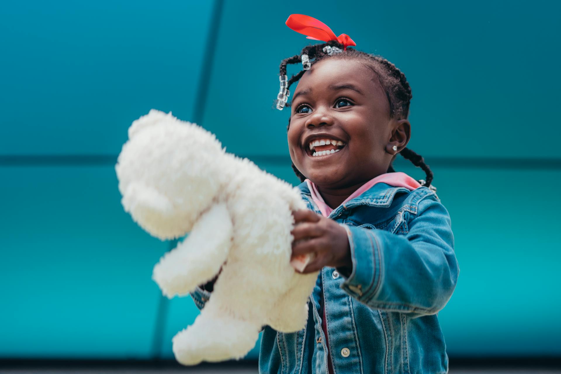 Glückliches junges Mädchen mit einem Teddy in der Hand | Quelle: Pexels