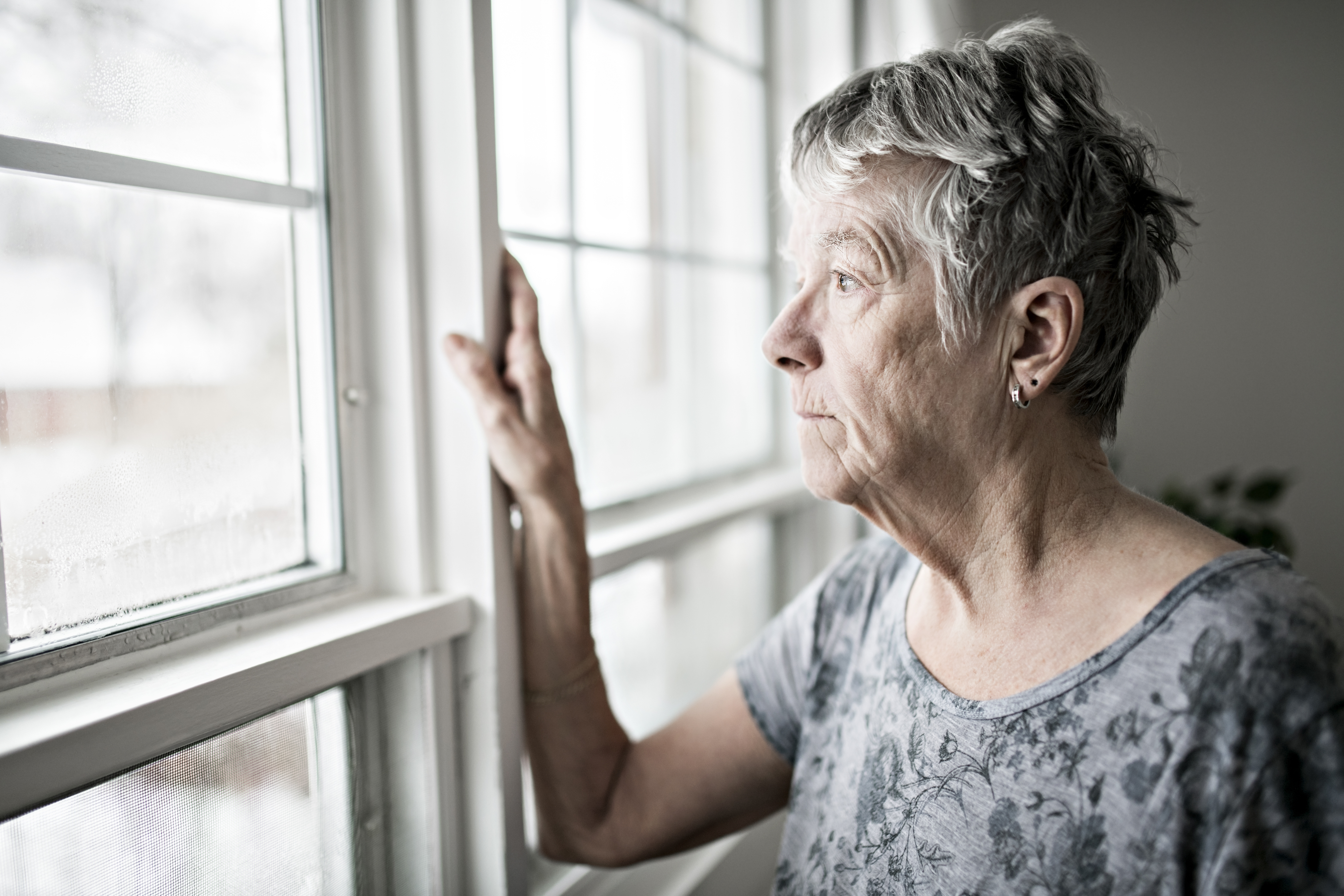 Verärgerte ältere Frau, die aus dem Fenster starrt | Quelle: Getty Images