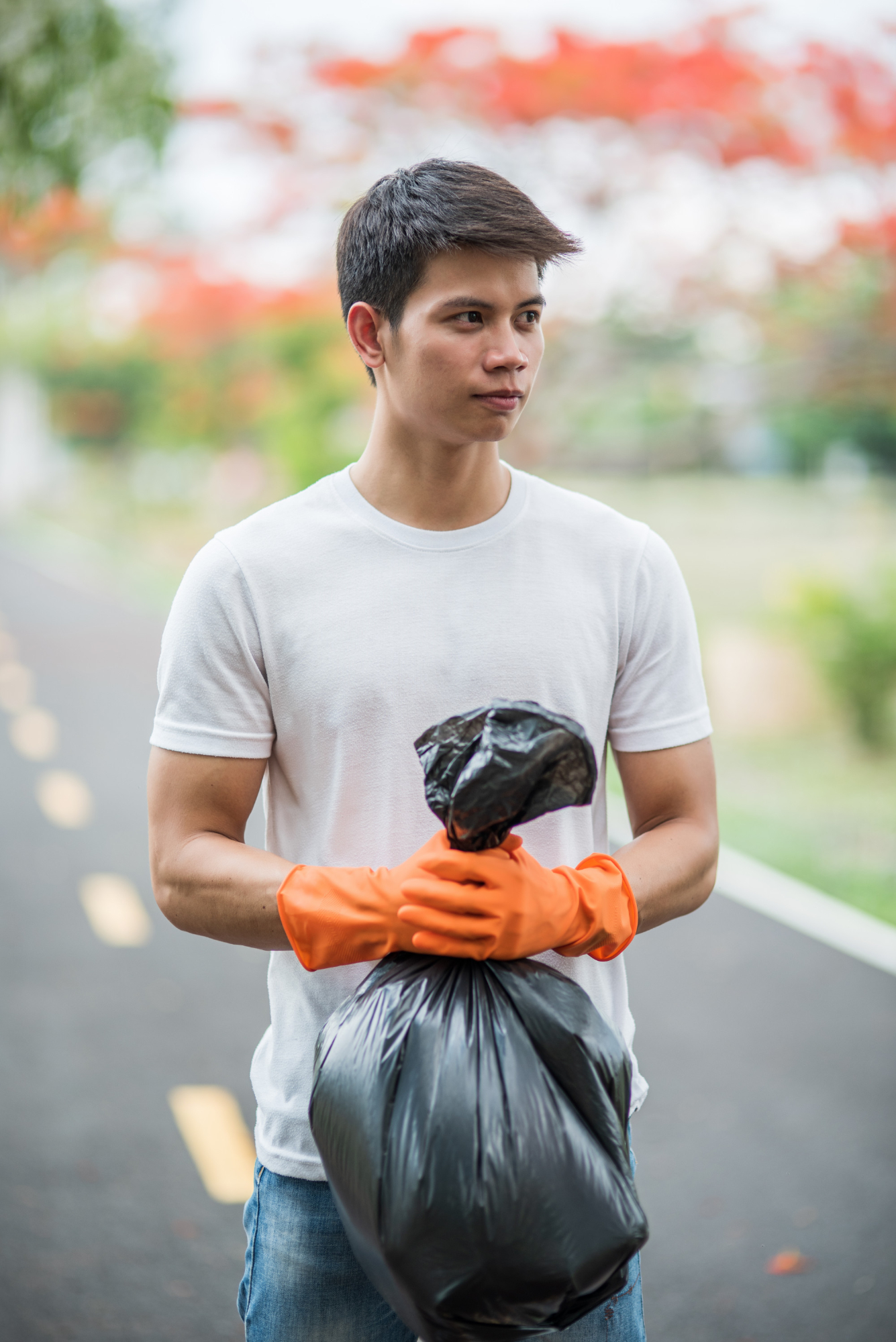 Ein Mann hält draußen einen Müllsack | Quelle: Freepik