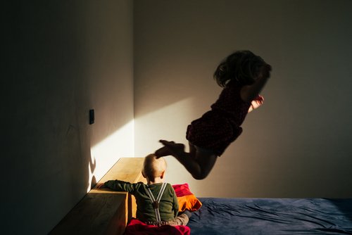 Kinder springen auf Bett | Quelle: Shutterstock