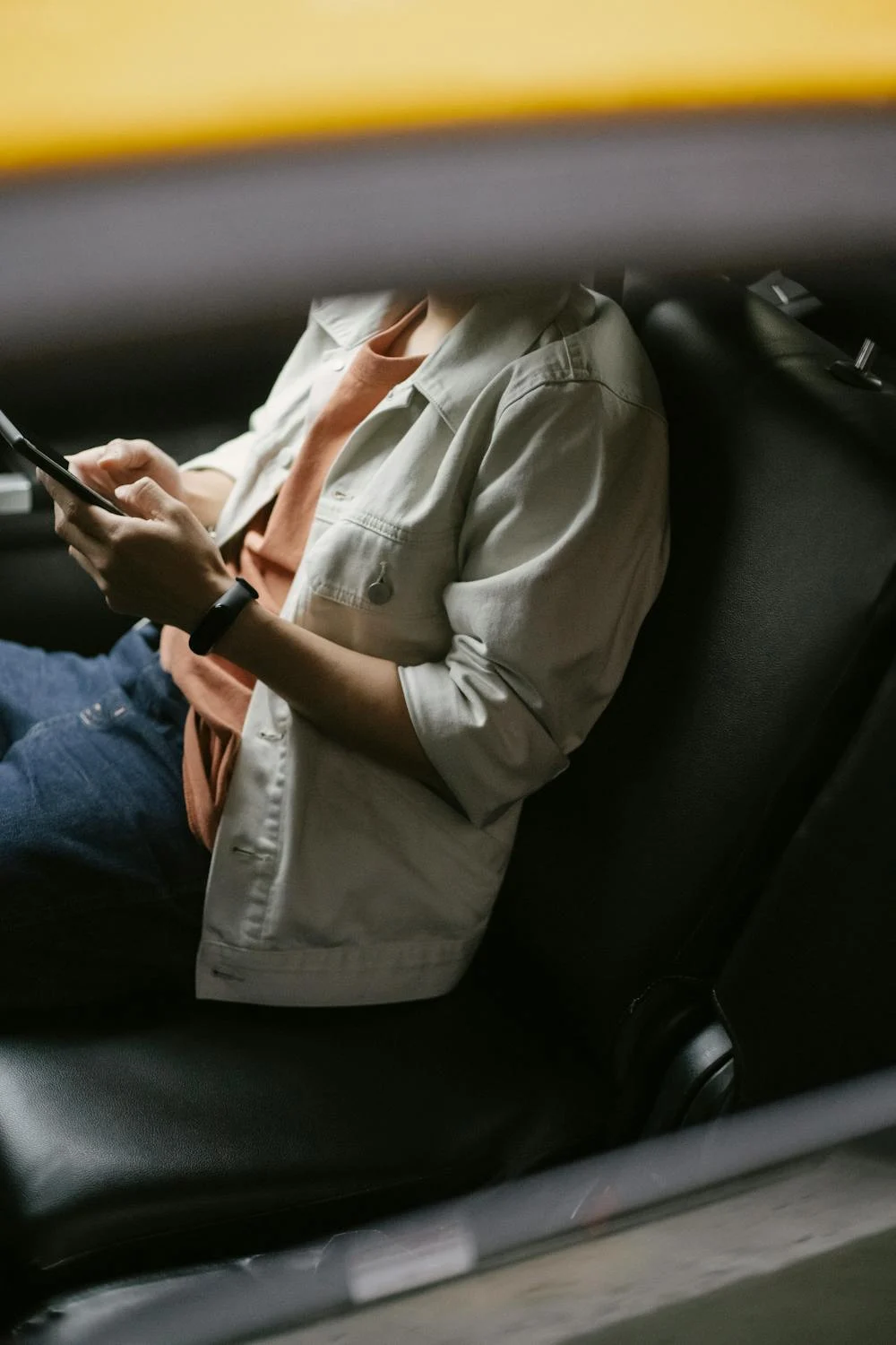Ein Mann, der in seinem Auto eine SMS schreibt | Quelle: Pexels