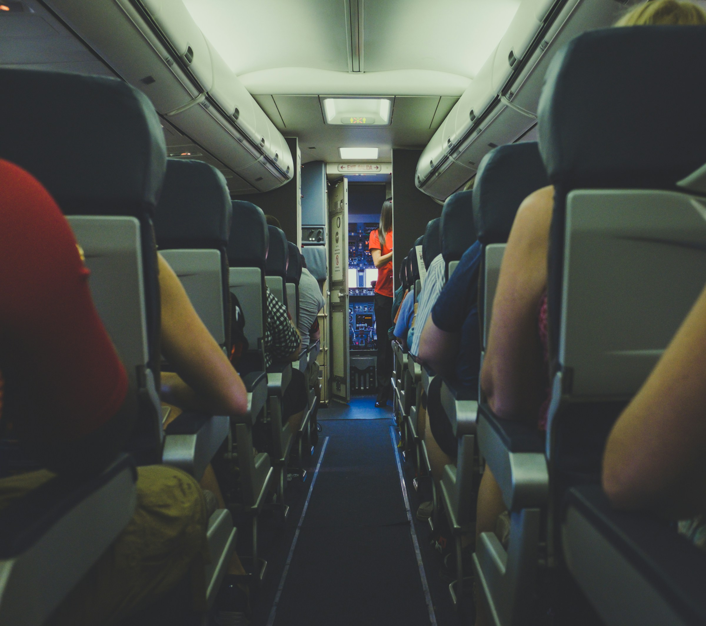 Eine Stewardess und Menschen in einem Flugzeug | Quelle: Unsplash