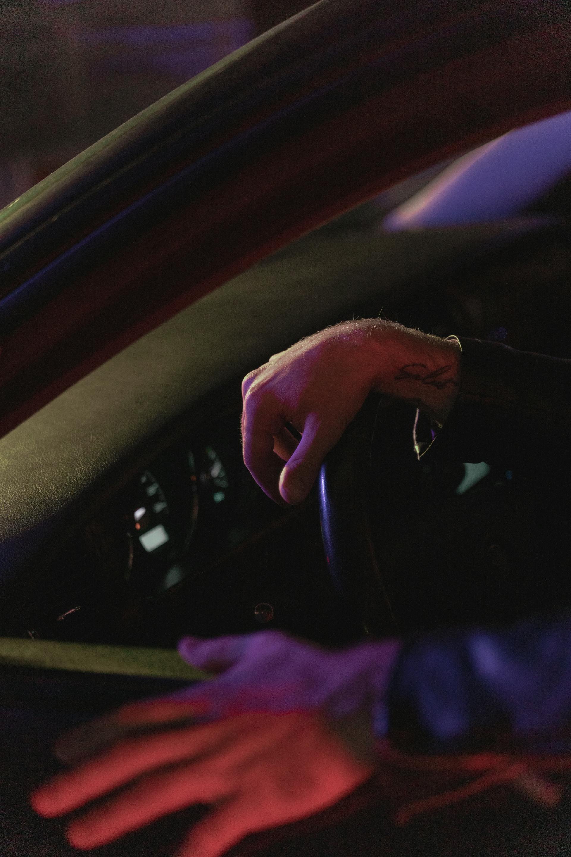 Die Hand eines Mannes am Lenkrad eines Autos | Quelle: Pexels