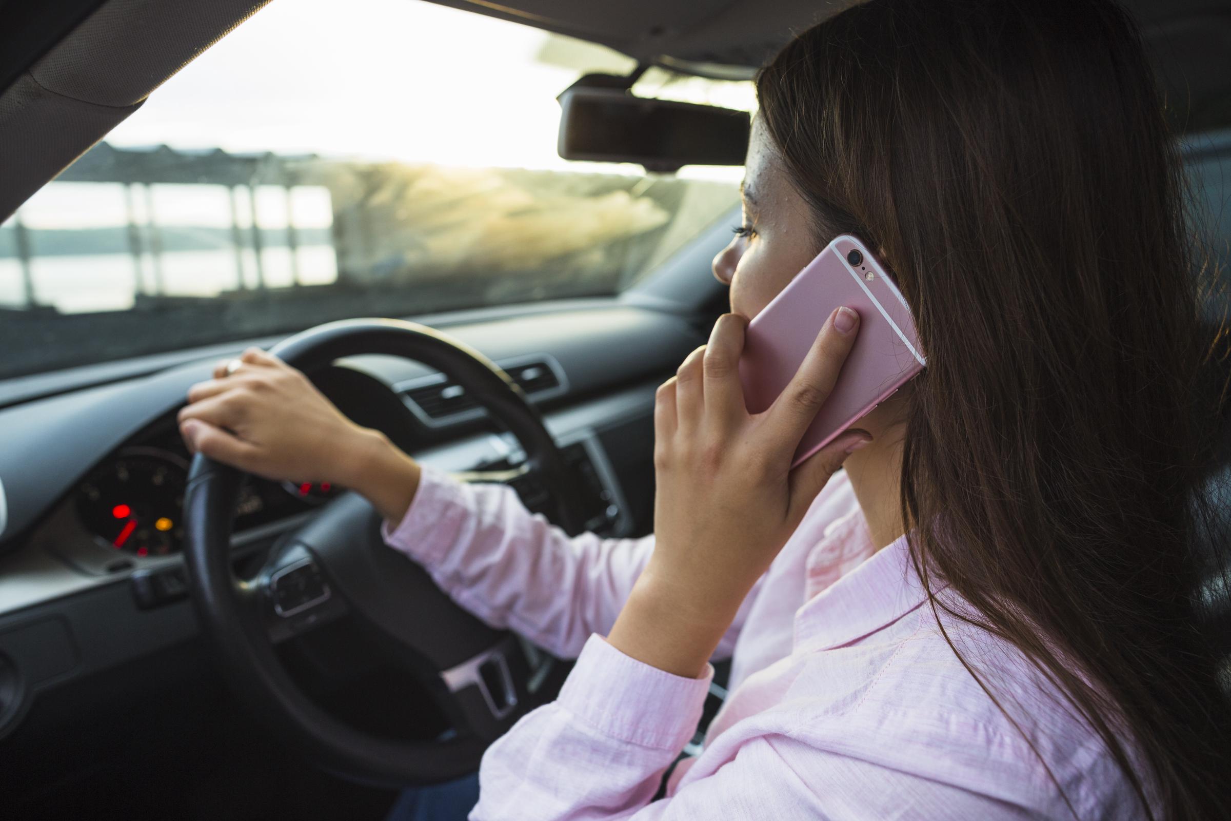 Eine Frau, die in ihrem Auto sitzt und telefoniert | Quelle: Freepik