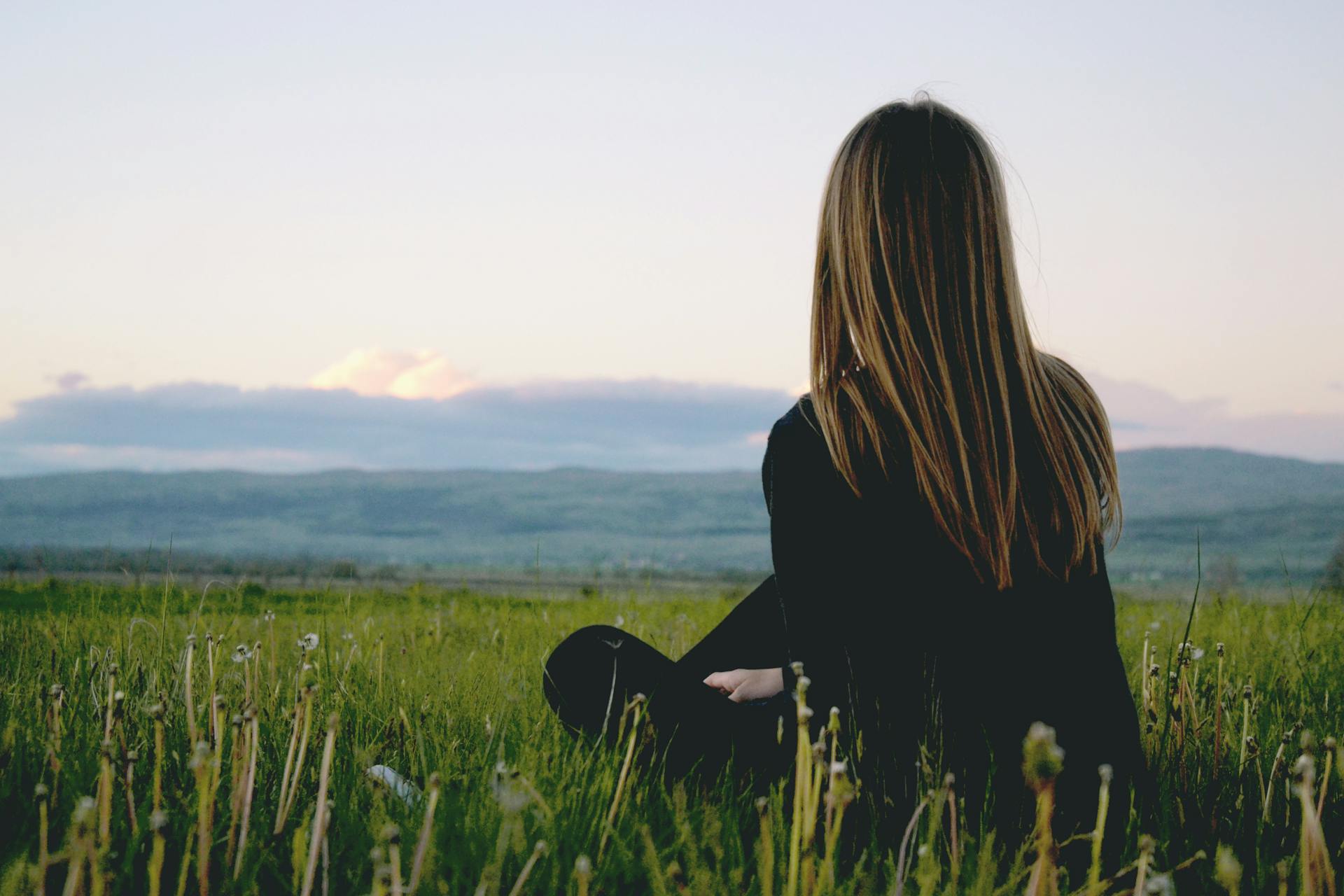 Eine Frau, die auf einem grasbewachsenen Feld sitzt | Quelle: Pexels