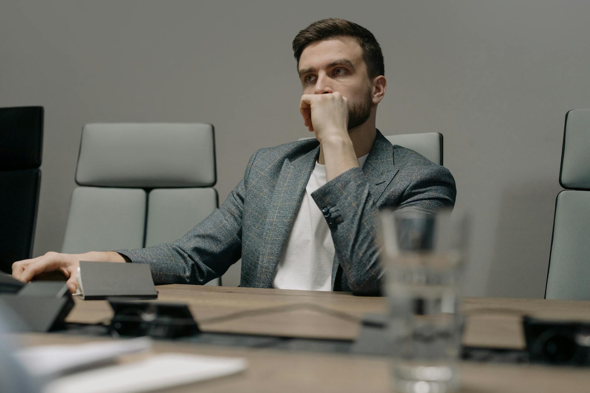 Ein Mann schaut nachdenklich, während er in seinem Büro sitzt | Quelle: Pexels