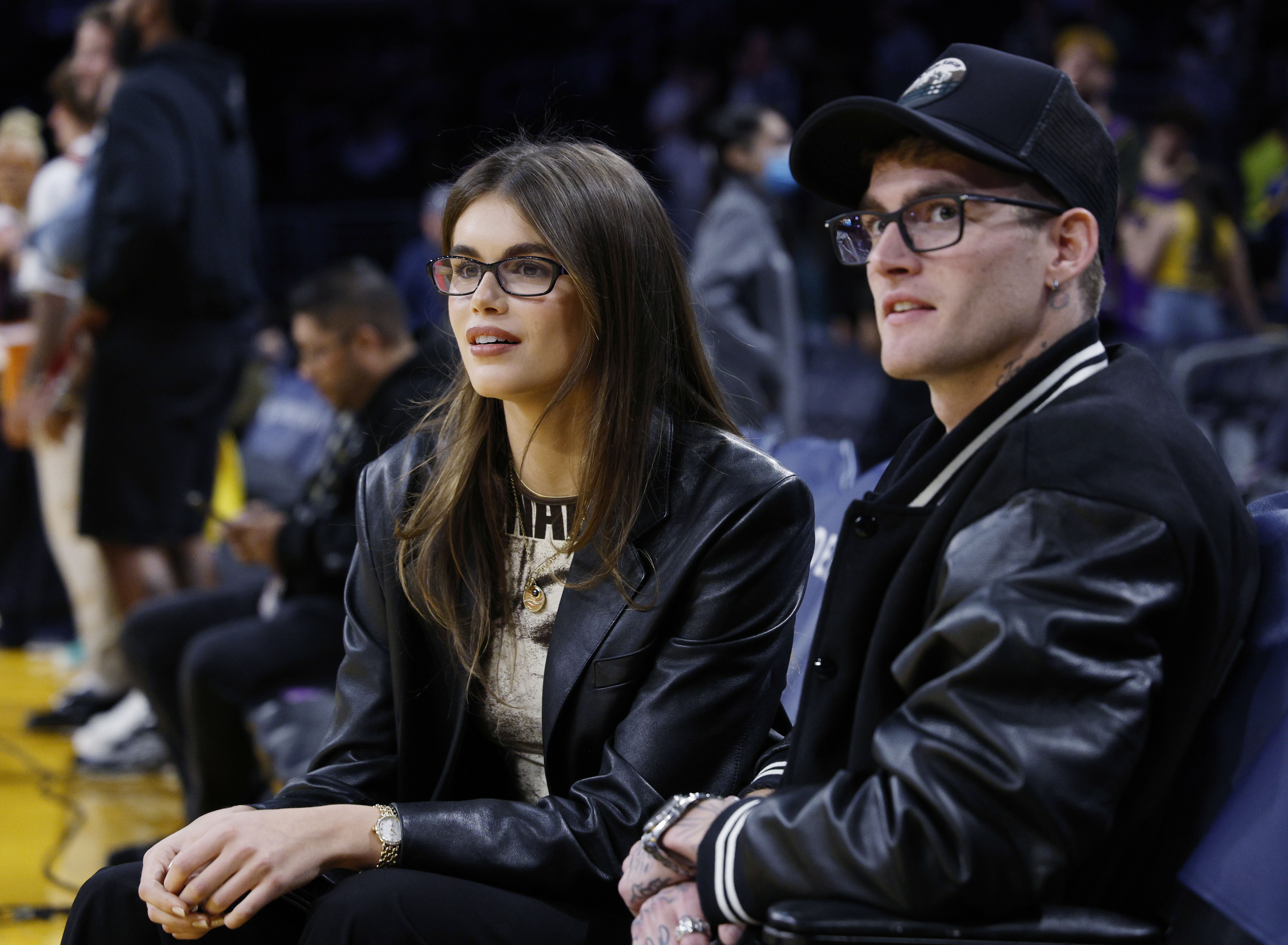 Kaia Gerber und Presley Gerber saßen am 23. Februar 2024 in der Crypto.com Arena in Los Angeles, Kalifornien, beim Spiel der Los Angeles Lakers gegen die San Antonio Spurs in passenden schwarzen Lederoutfits und mit stylischen Brillen direkt am Spielfeldrand. Die modebewussten Geschwister zeigten ihre enge Verbundenheit, während sie das Spiel verfolgten: Kaia kombinierte einen schicken Lederblazer mit dezentem Goldschmuck, und Presley trug eine zweifarbige Varsity-Bomberjacke über einer schwarzen Baseballkappe. | Quelle: Getty Images