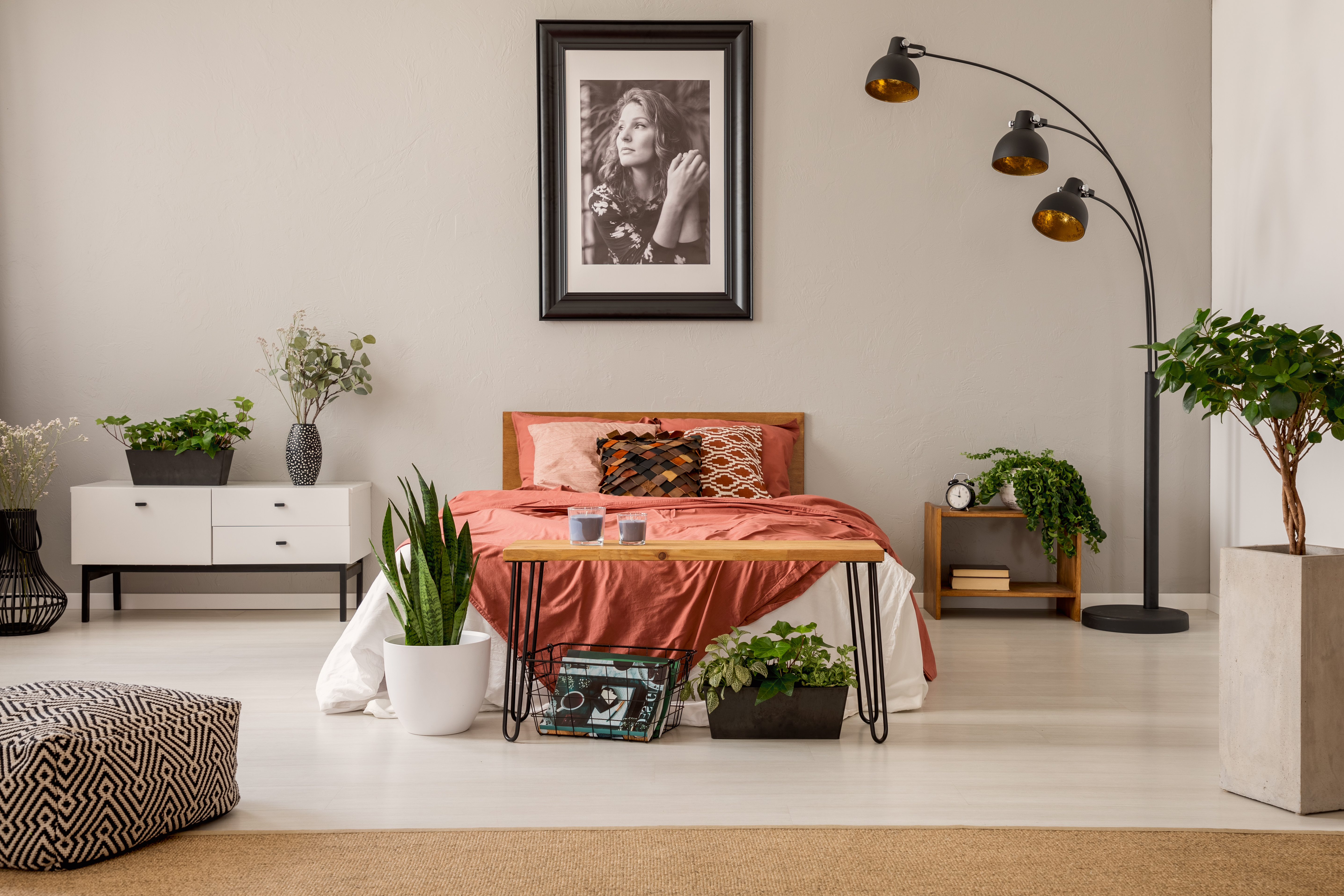 Ein gemütliches Schlafzimmer mit einem Foto einer Frau, das über dem Bett hängt | Quelle: Shutterstock