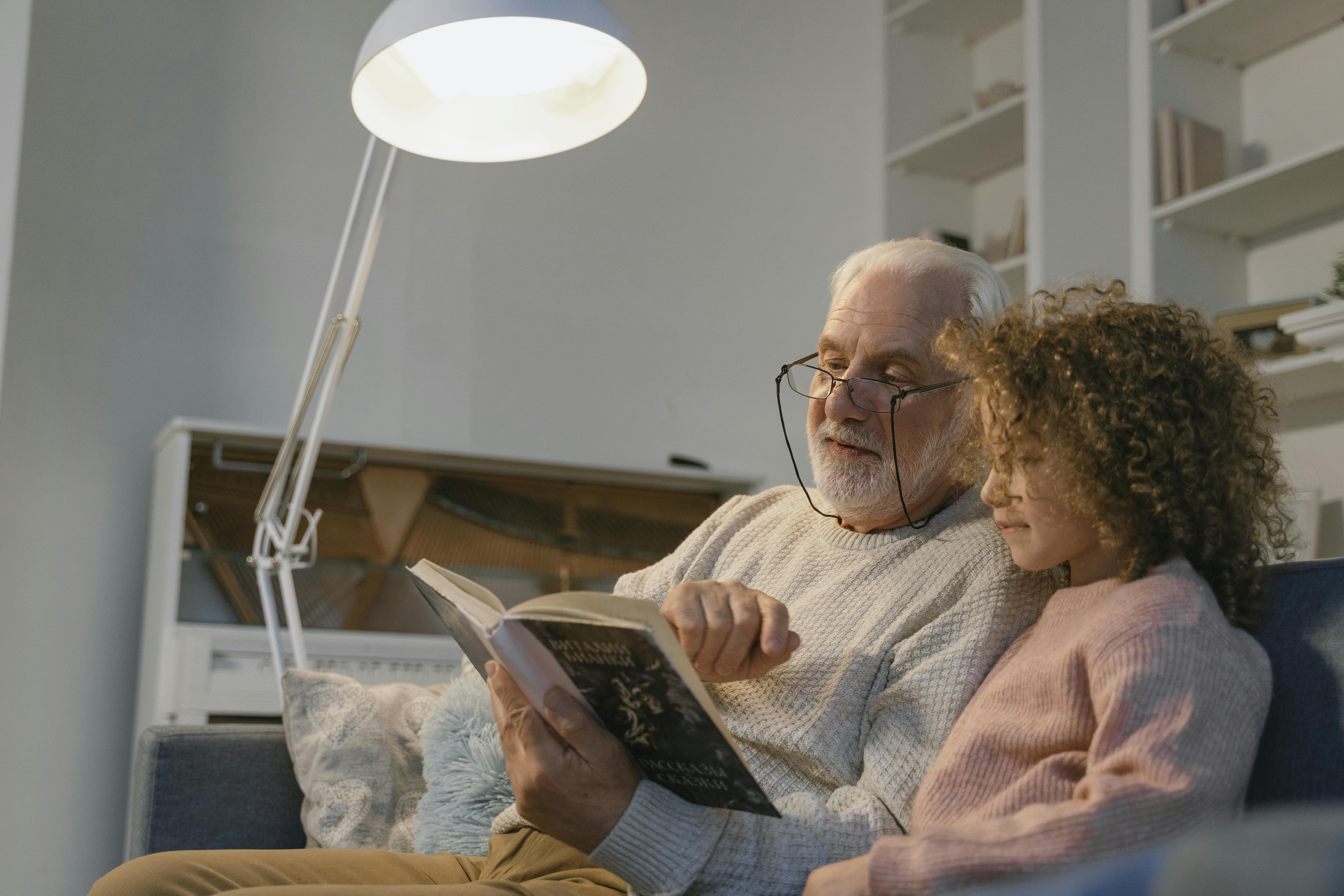 Ein Großvater liest seiner Enkelin ein Buch vor | Quelle: Pexels