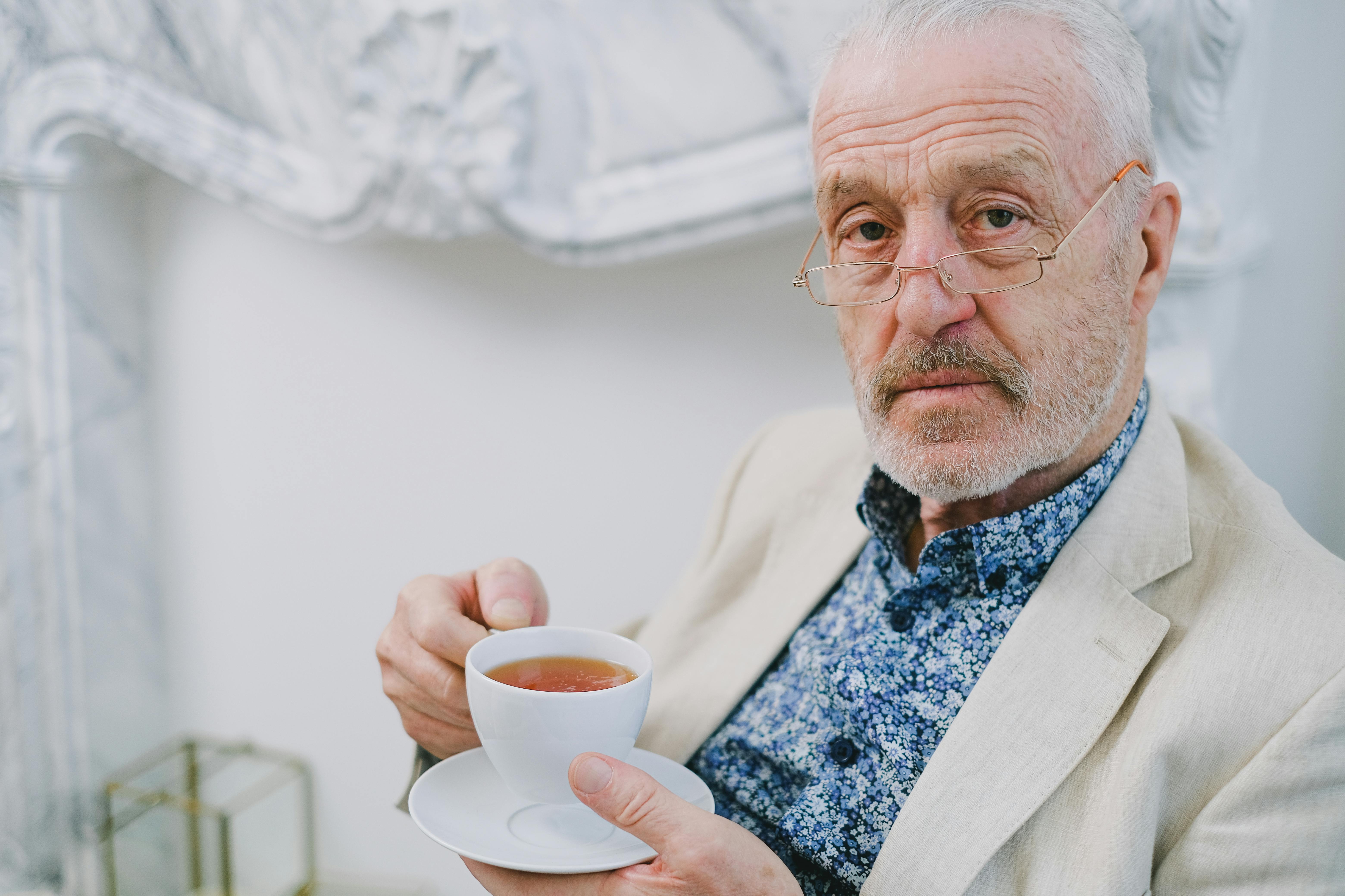 Ein ernster Mann mit einer Tasse Tee in der Hand | Quelle: Pexels