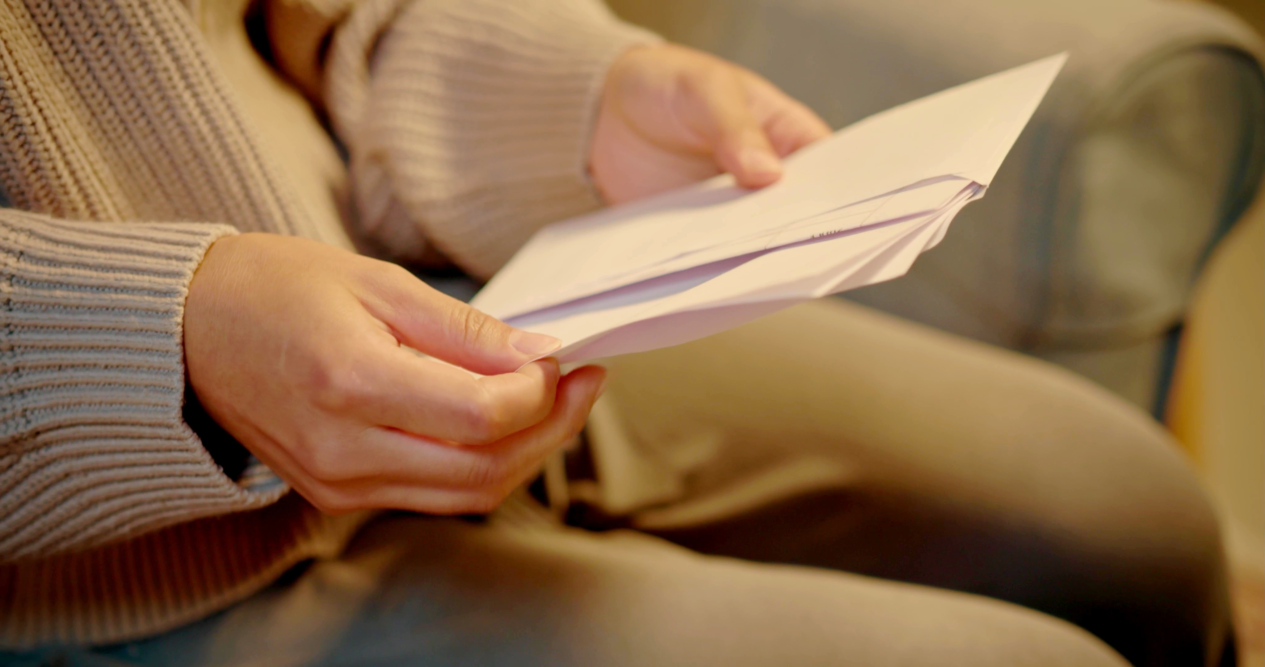 Eine Frau öffnet einen Umschlag | Quelle: Shutterstock