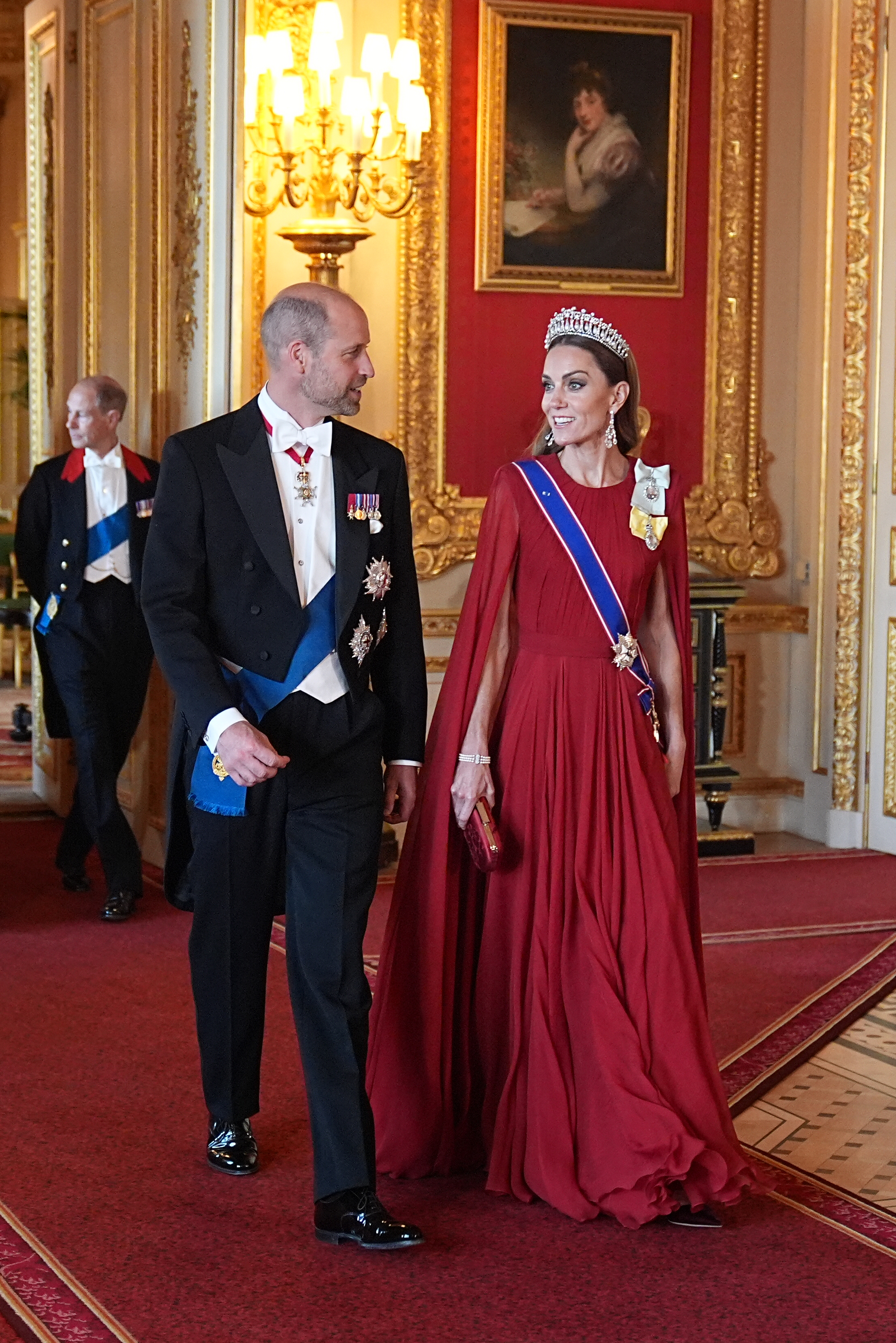 Prinz William und Catherine, Prinzessin von Wales, haben am 8. Juli 2025 im Windsor Castle einen grandiosen Auftritt beim Staatsbankett zu Ehren des französischen Präsidenten Emmanuel Macron und seiner First Lady Brigitte Macron. Catherine zieht alle Blicke auf sich in einem plissierten, purpurroten Cape-Kleid, kombiniert mit Königin Marys „Lover’s Knot“-Tiara, Diamant-Ohrringen, der Schärpe des Royal Victorian Order und dem Royal Family Order von König Charles III. Sie lächelt neben William, der einen formellen Windsor-Frack mit weißer Krawatte und voller zeremonieller Ehren trägt. | Quelle: Getty Images