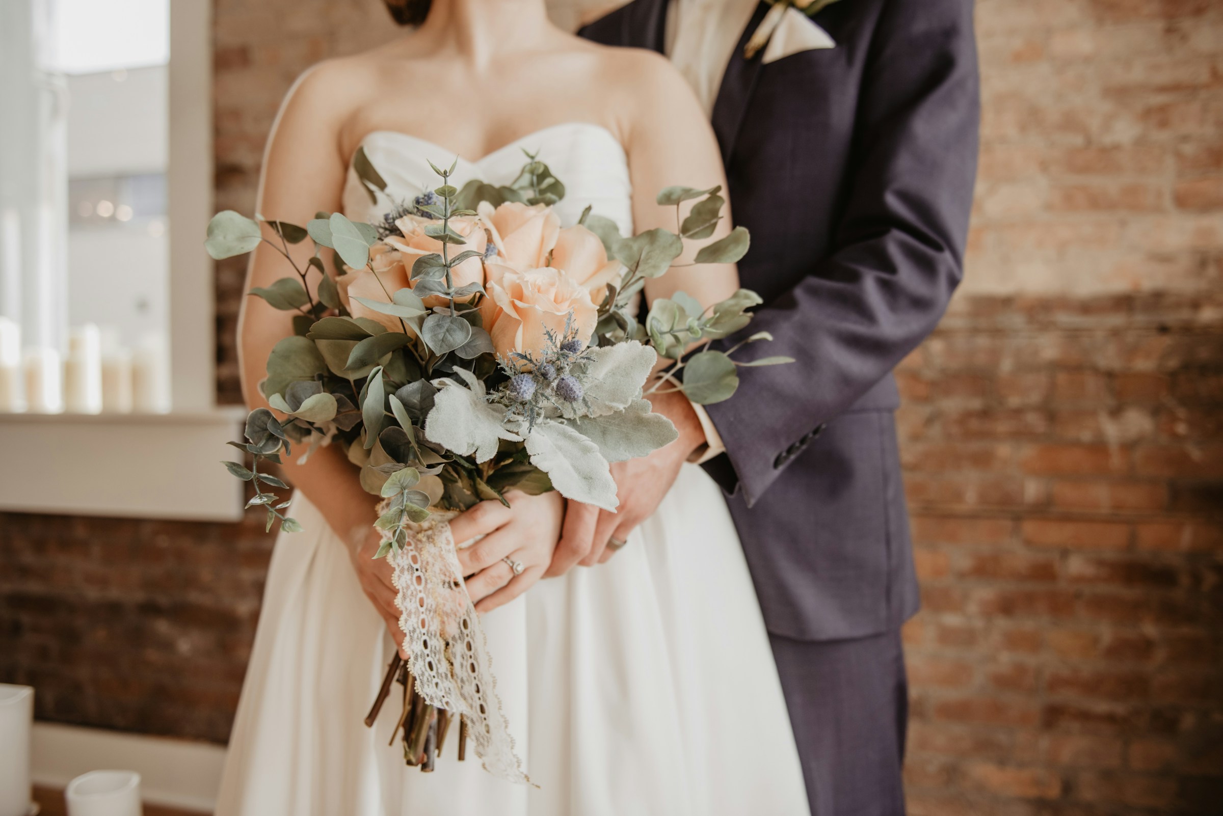 Eine Braut und ein Bräutigam halten sich an den Händen | Quelle: Unsplash