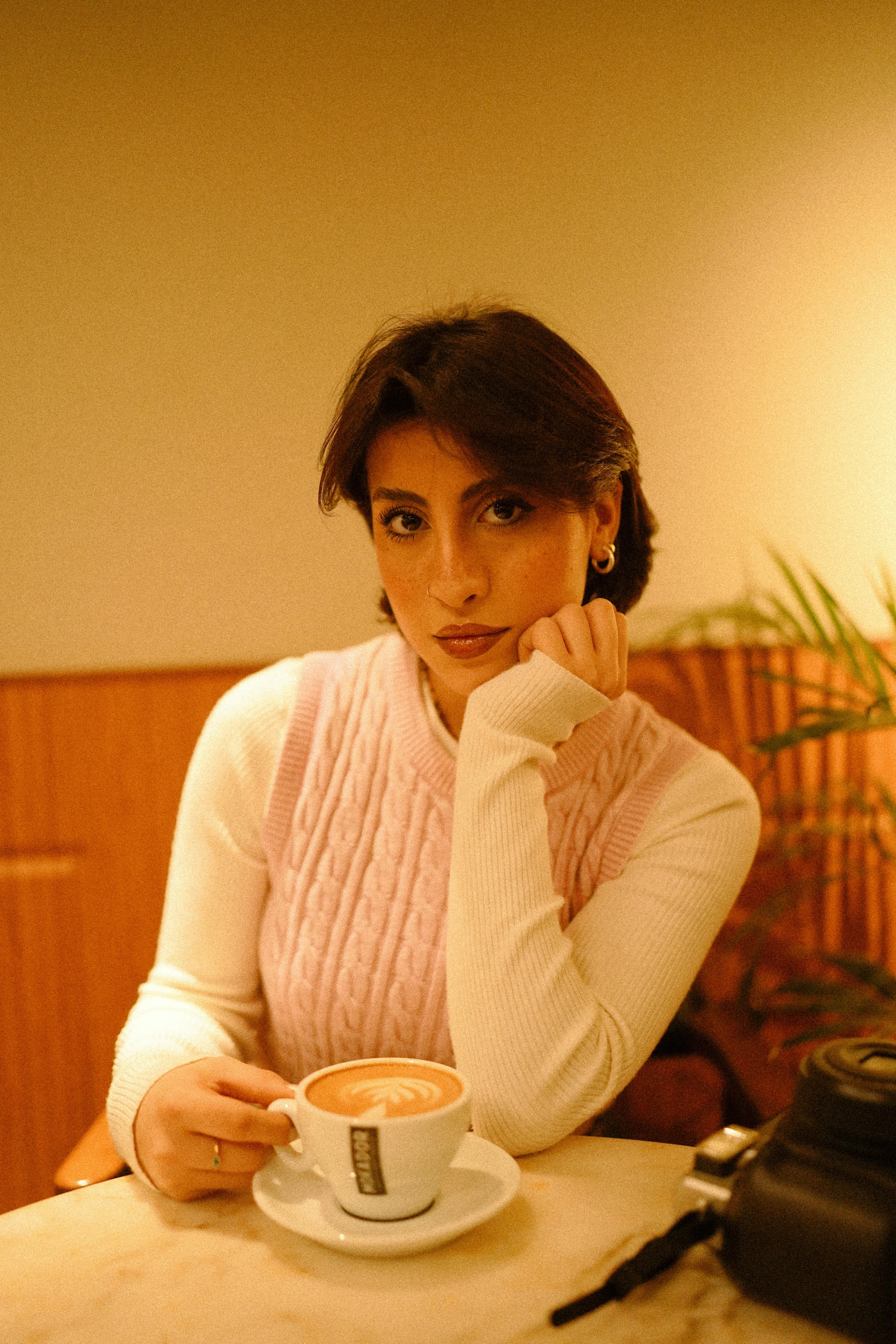 Eine Frau schaut unbeeindruckt beim Kaffee trinken | Quelle: Pexels