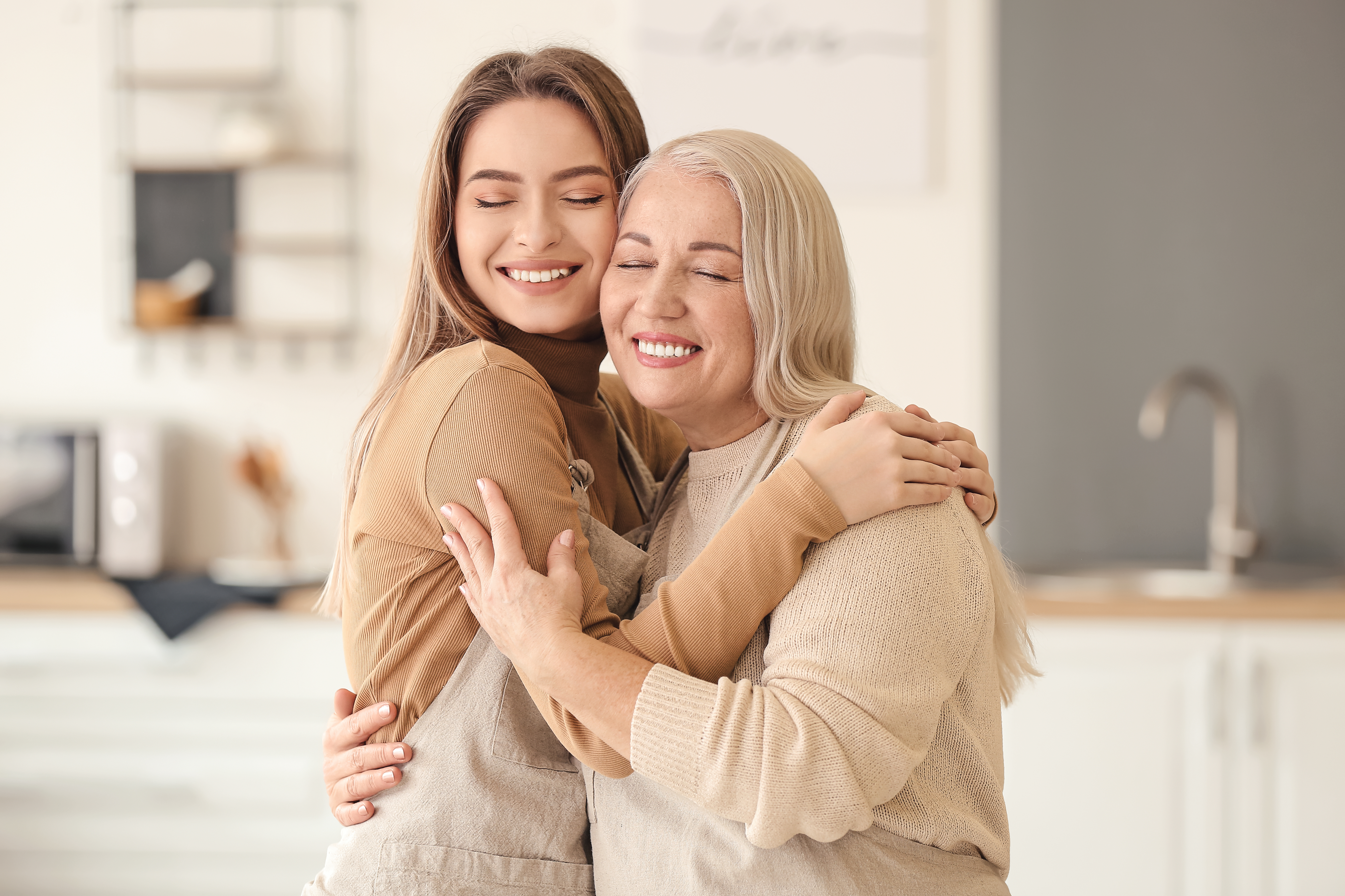 Eine jüngere Frau, die ihre ältere Mutter umarmt | Quelle: Shutterstock