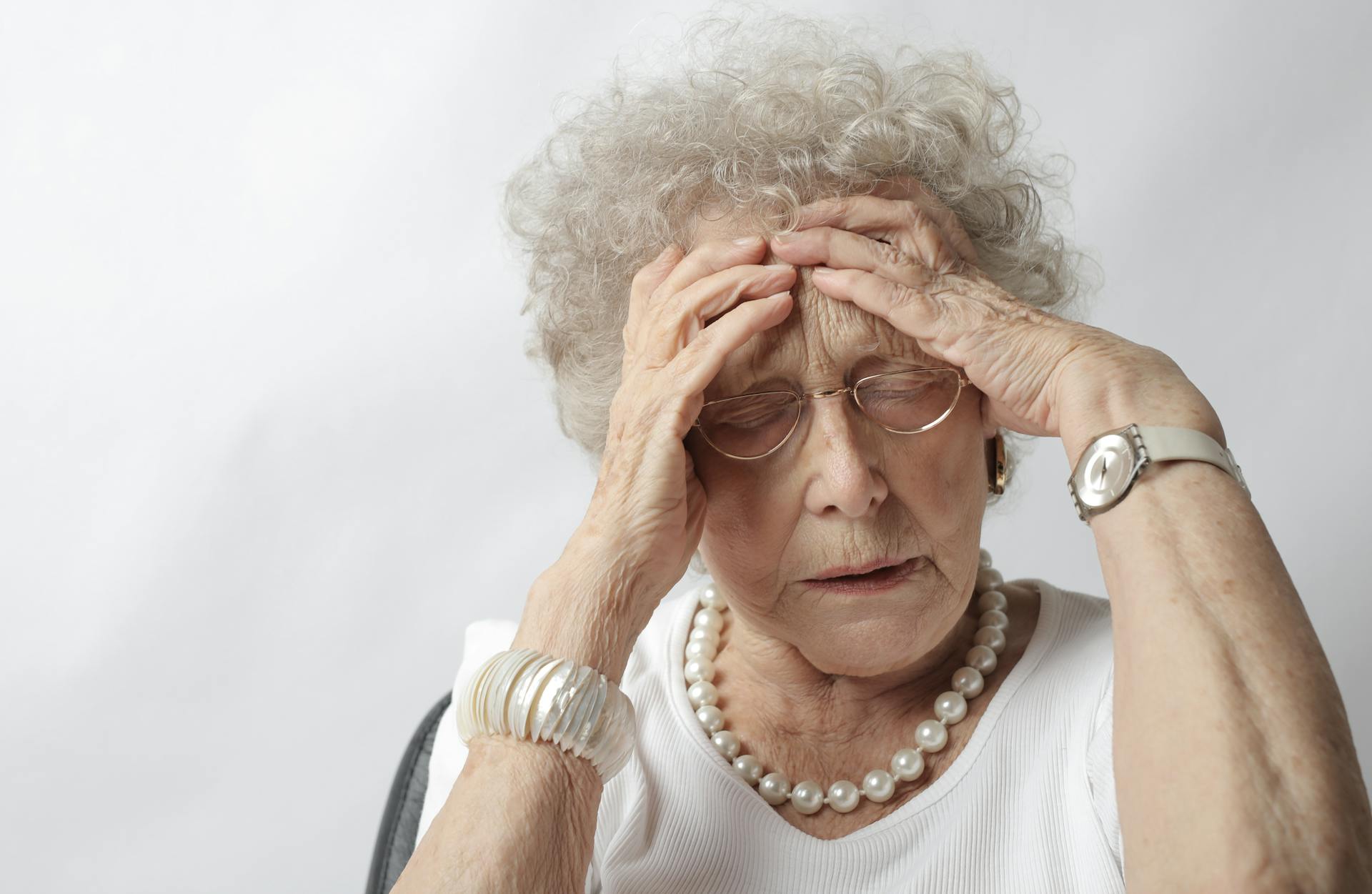 Eine alte Frau mit ihren Händen auf dem Kopf | Quelle: Pexels