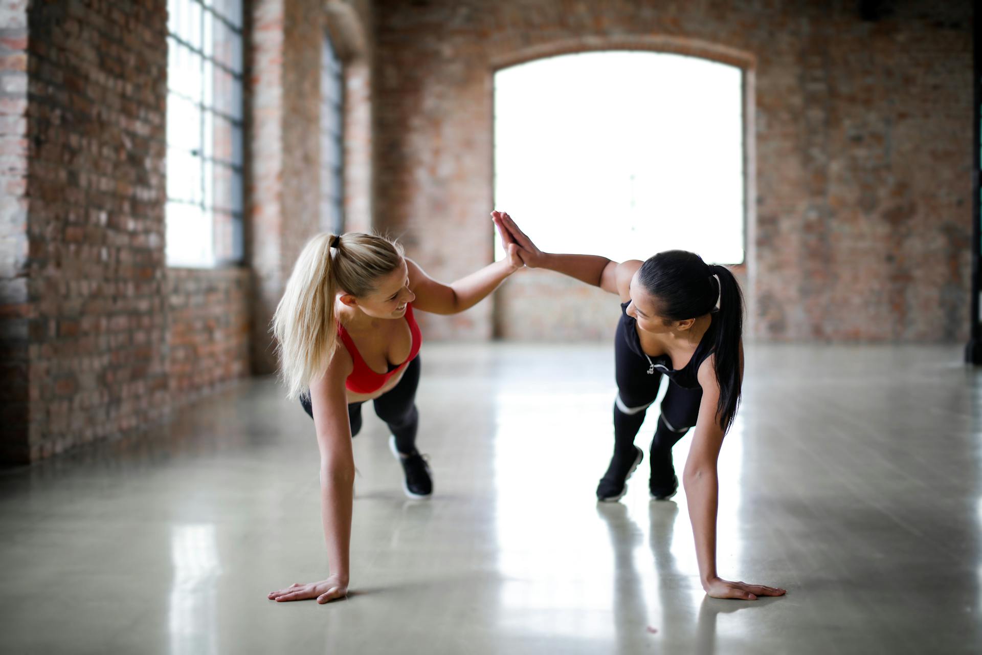 Zwei Frauen geben sich beim gemeinsamen Training ein High-Five | Quelle: Pexels