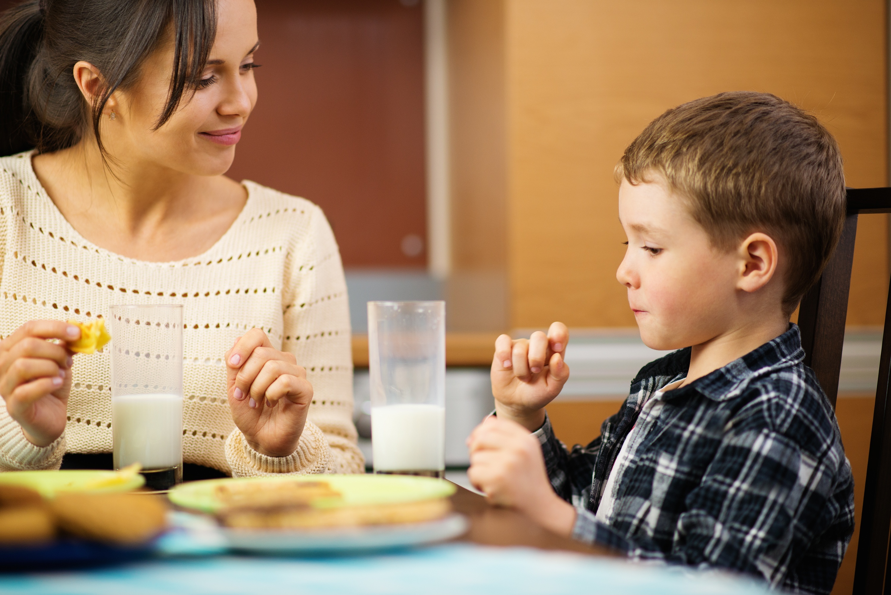 Junge glückliche Mutter und ihr Kind beim Essen. | Quelle: Shutterstock