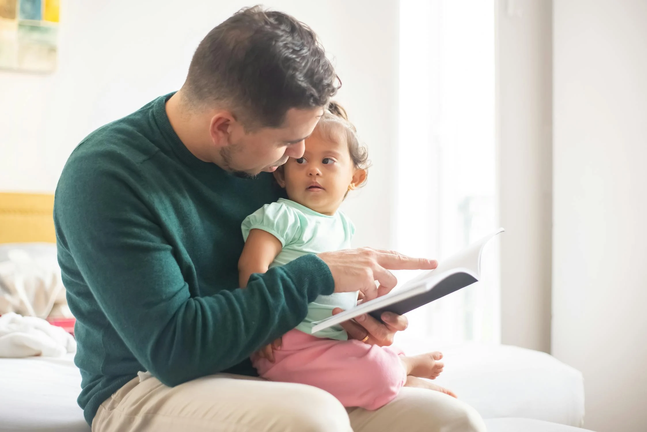 Ein Mann liest seiner Tochter ein Buch vor | Quelle: Pexels