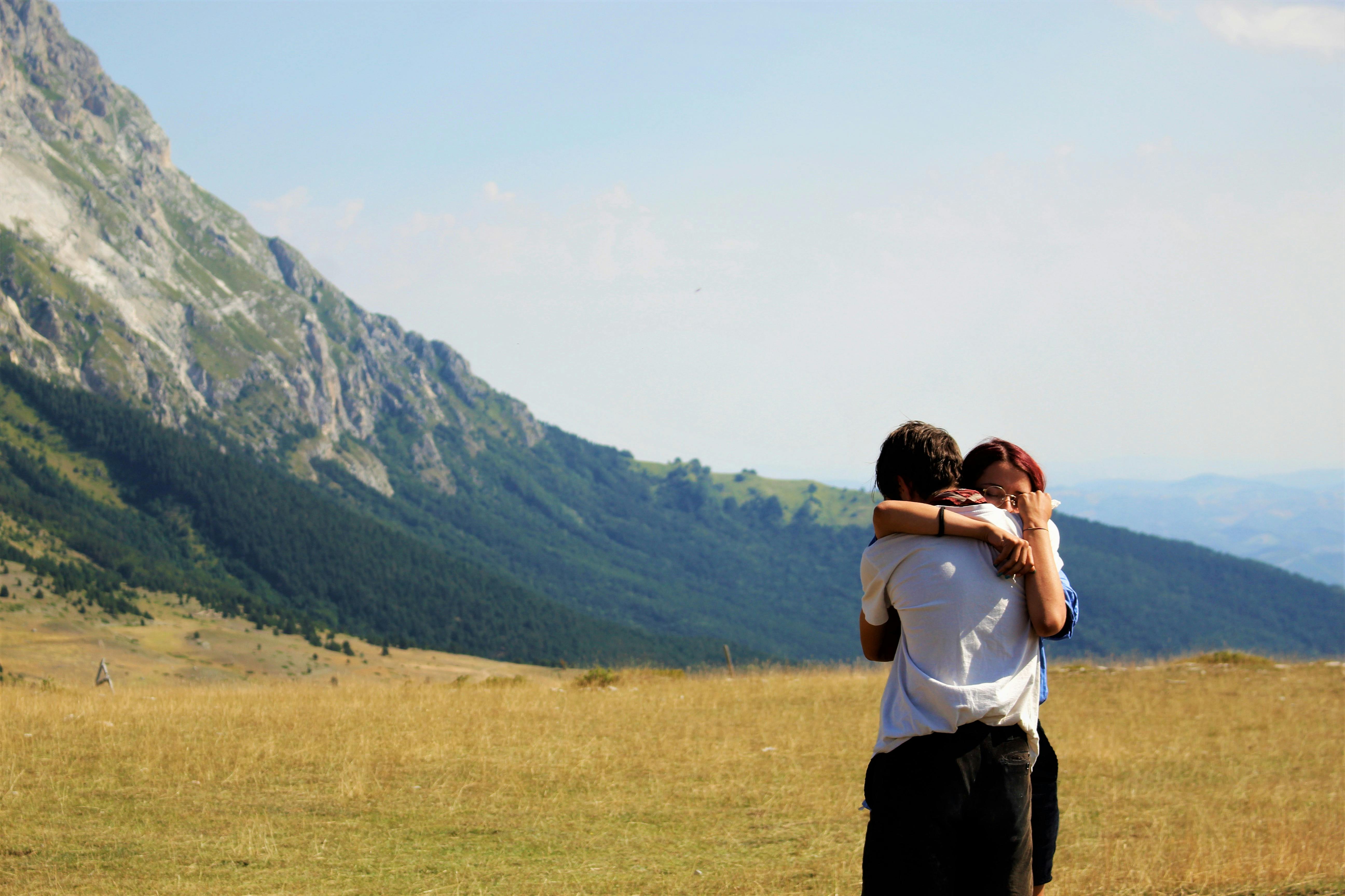 Ein sich umarmendes Paar auf einer Wiese | Quelle: Pexels