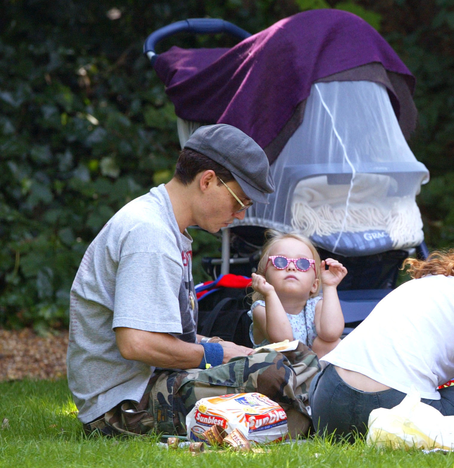 Johnny Depp und Lily-Rose Depp bei einem Picknick in einem Londoner Park, am 14. Juli 2002 | Quelle: Getty Images