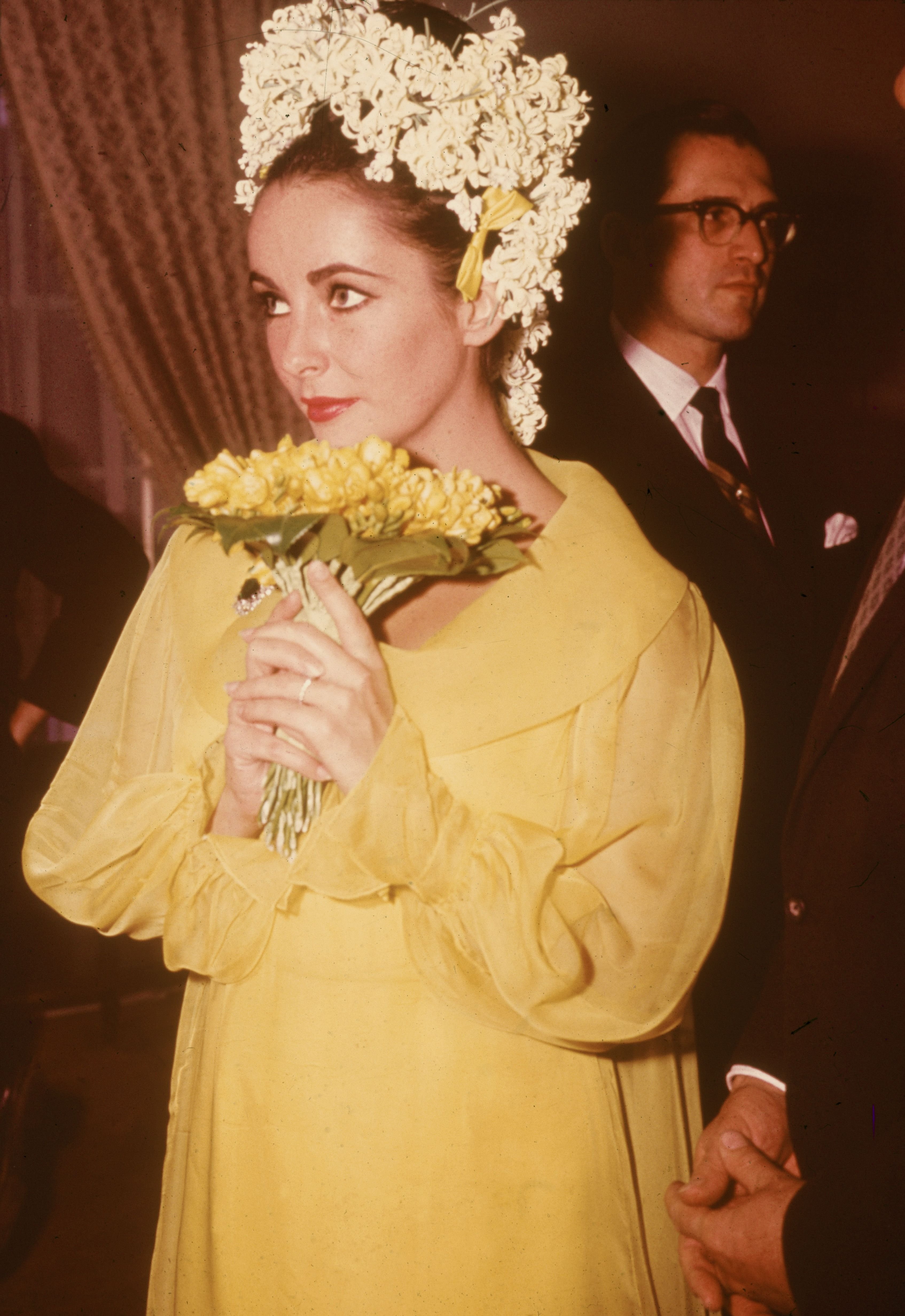 Elizabeth Taylor hält einen Blumenstrauß bei ihrer Hochzeit mit dem Schauspieler Richard Burton am 15. März 1964.| Quelle: Hulton Archive/Getty Images