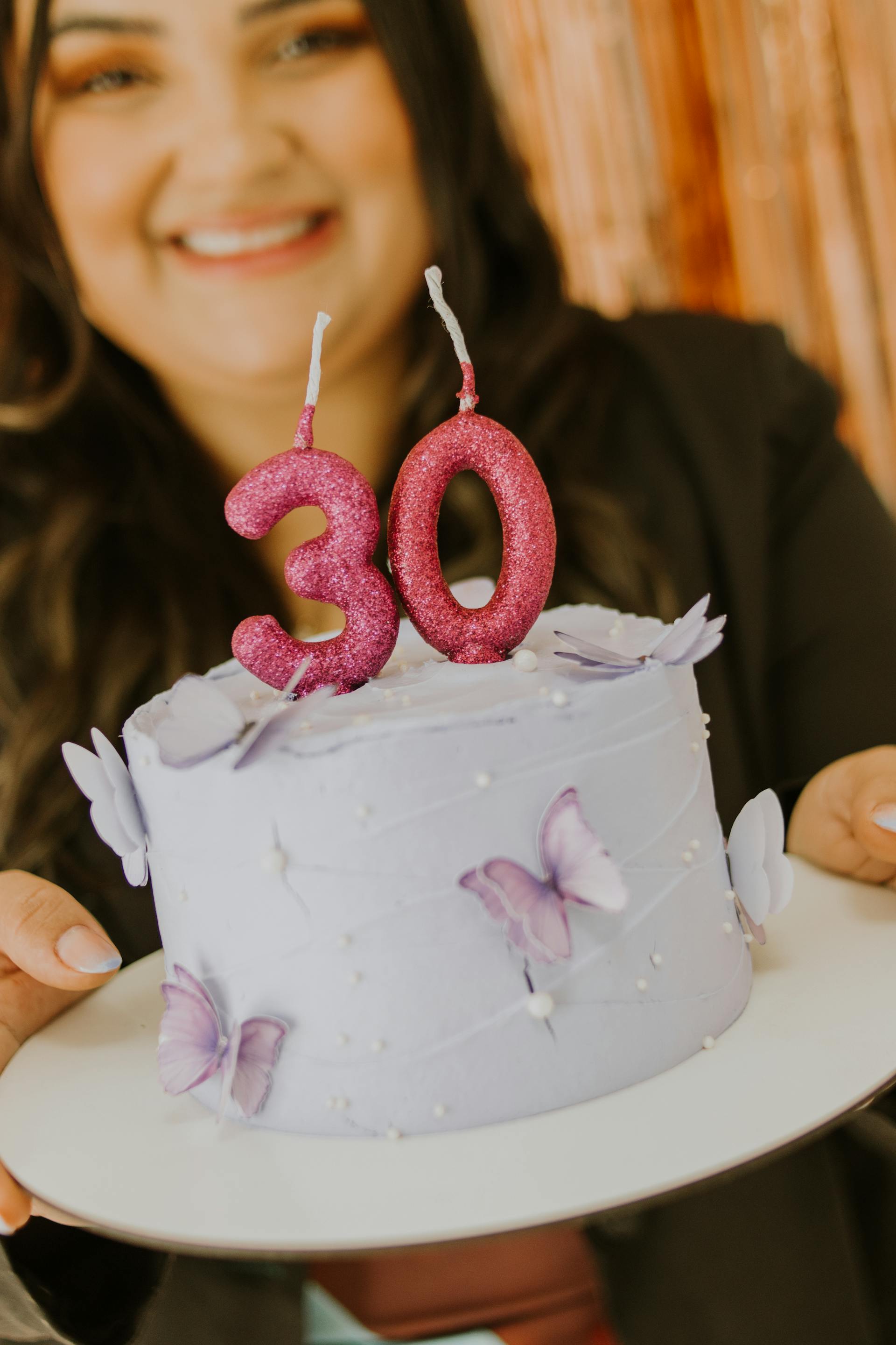 Eine Frau hält eine lila Geburtstagstorte | Quelle: Pexels